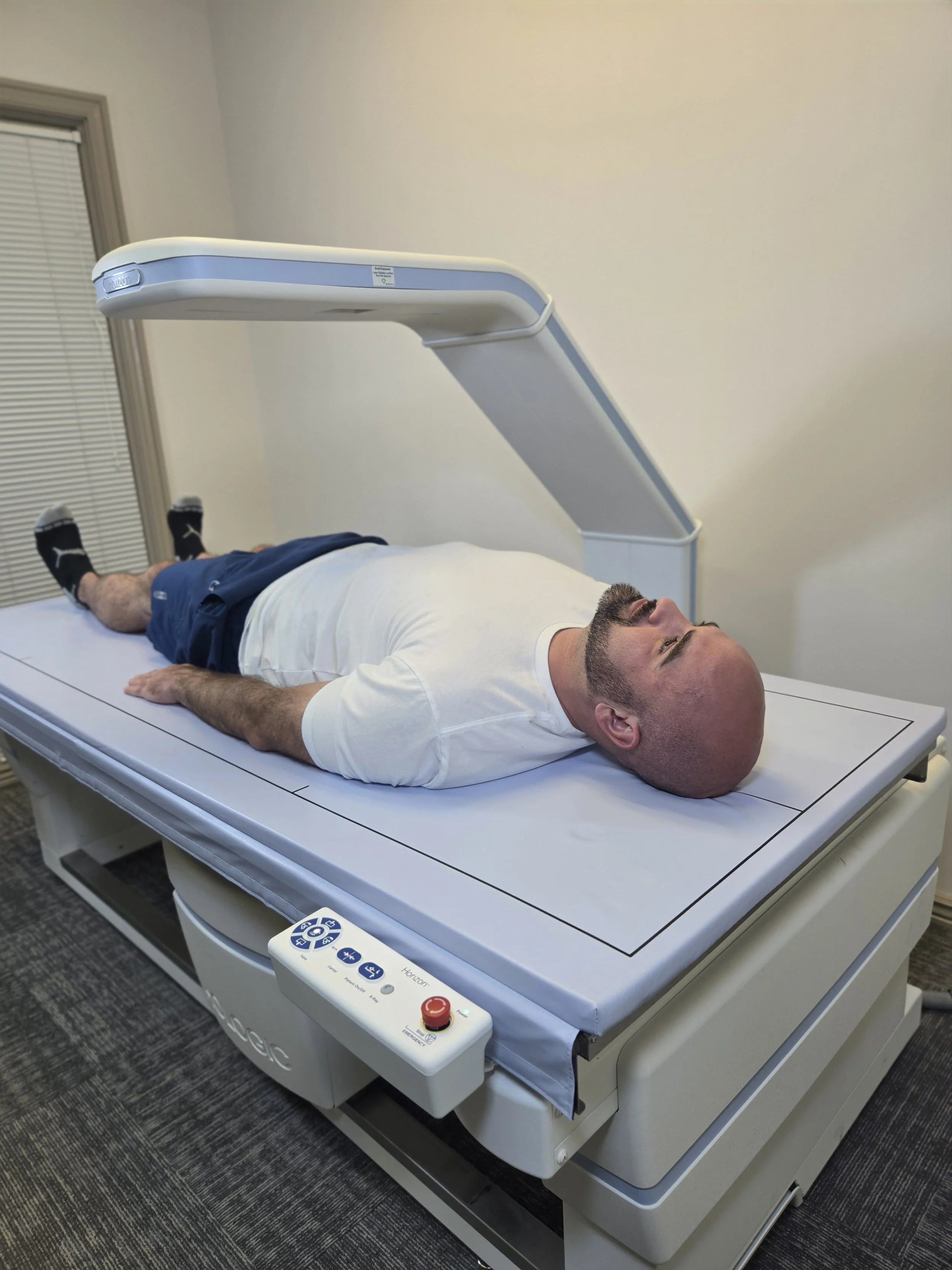 Patient receiving a dual-energy x-ray absorptiometry (DEXA) scan for precise body composition analysis at a clinical testing facility in Davis County