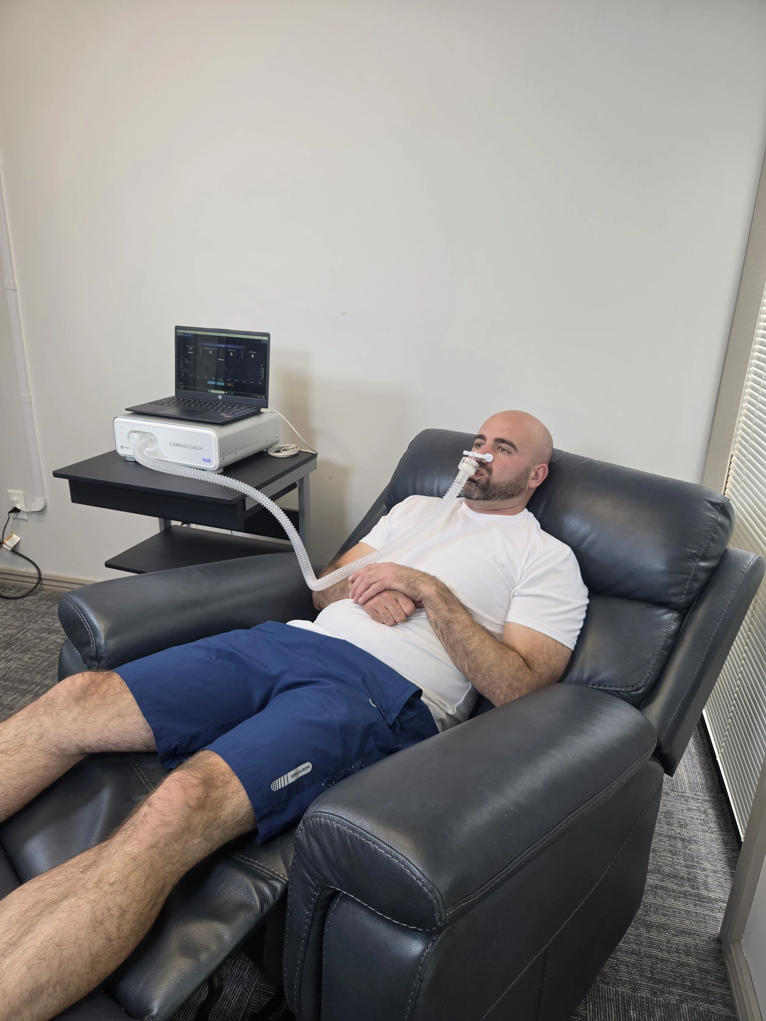 A client resting comfortably in a chair while wearing a metabolic mask for a Resting Metabolic Rate (RMR) test via indirect calorimetry at Health InSight LLC in Layton, Utah.