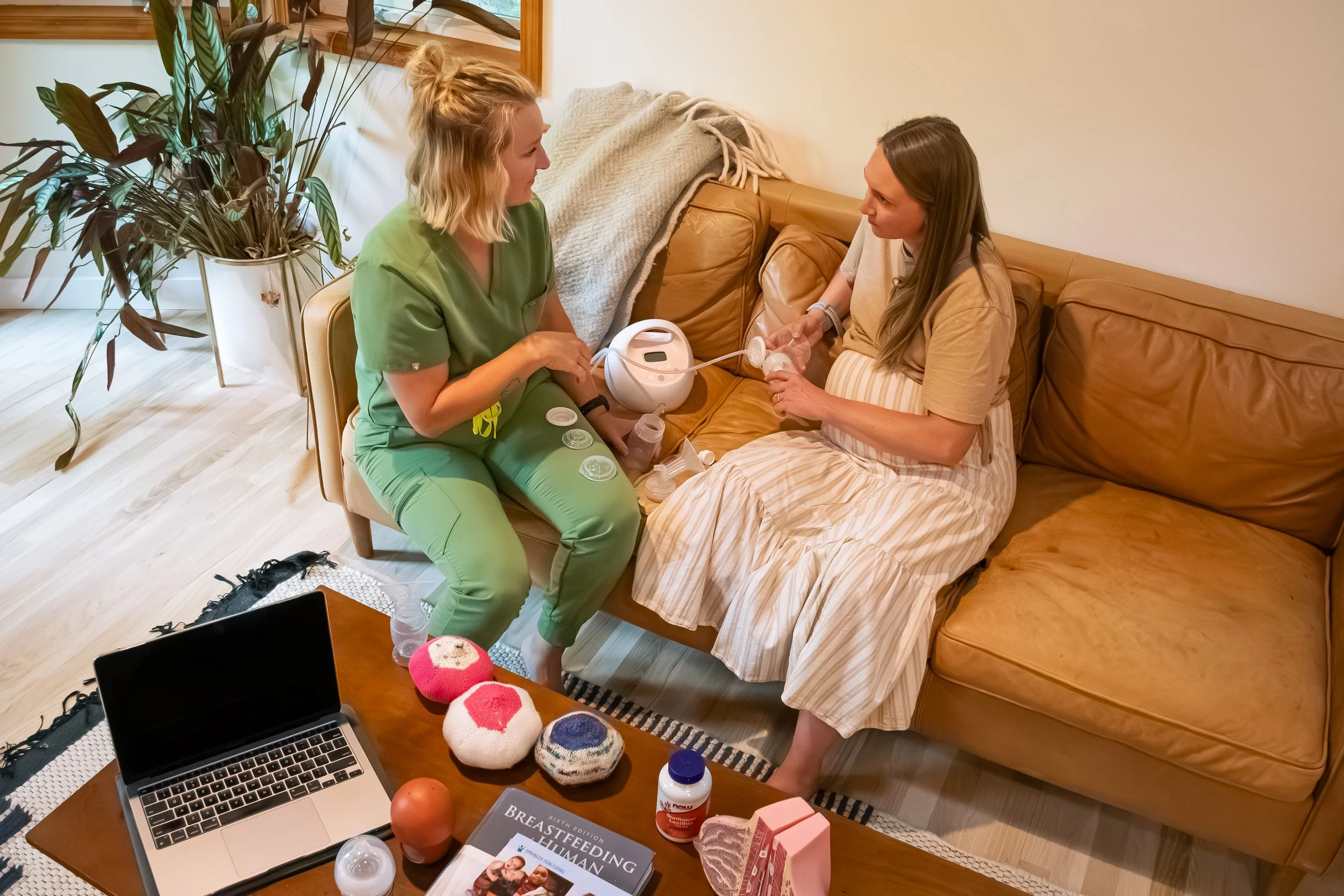 Image of lactation consultant meeting with an expecting mother in the comfort of her own home. Talking about what to expect with breastfeeding and pumping.