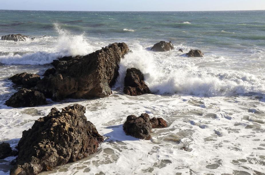 Ocean waves breaking against rocks, symbolizing emotional challenges, resilience, and growth explored through relationship counselling for adults at Neurodiversity Wellness Collective.