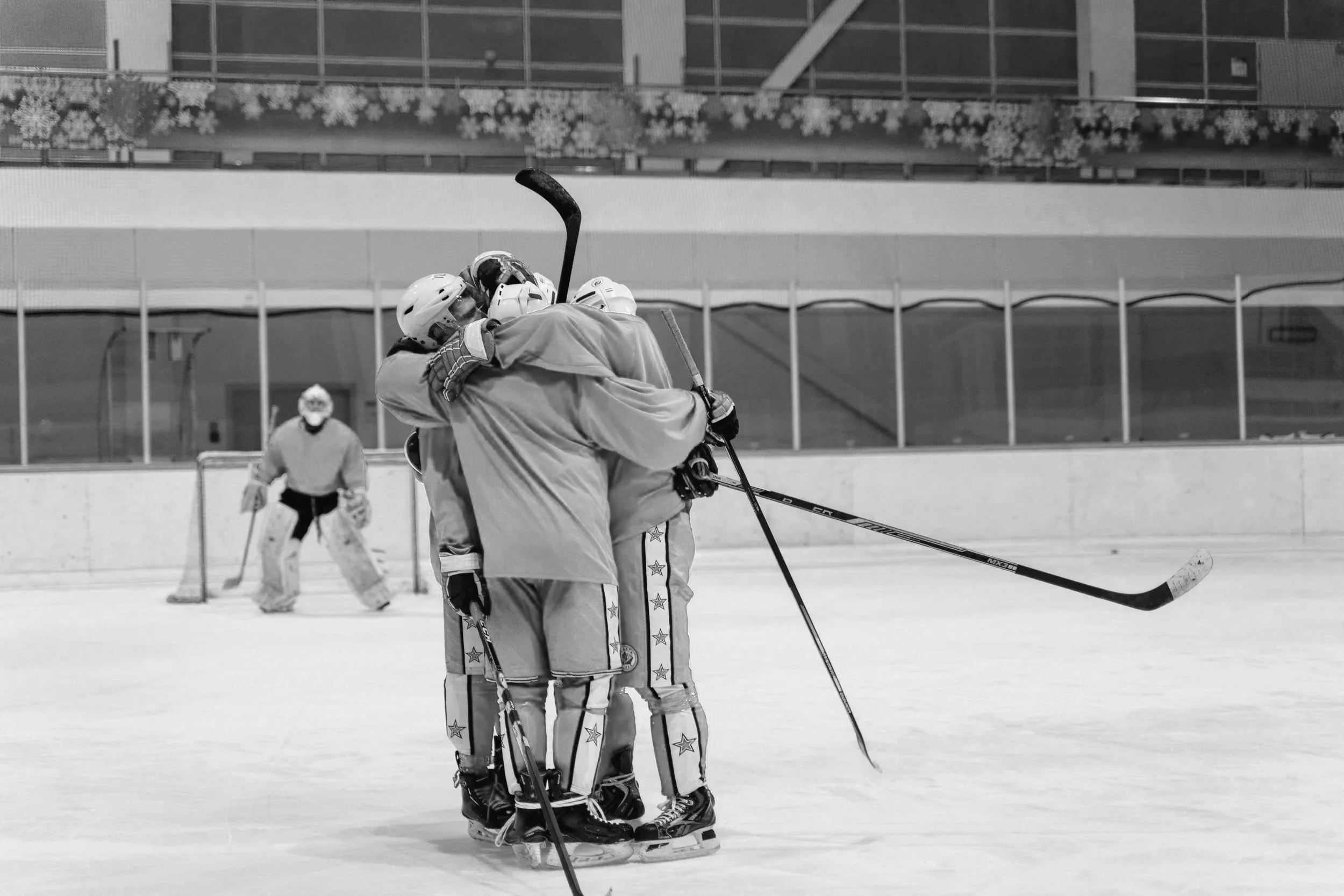 Hockey team embracing after scoring a goal.