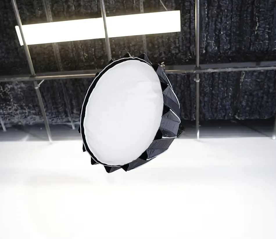 Professional overhead softbox lighting and ceiling rigging grid inside a white cyclorama photography and video production studio.