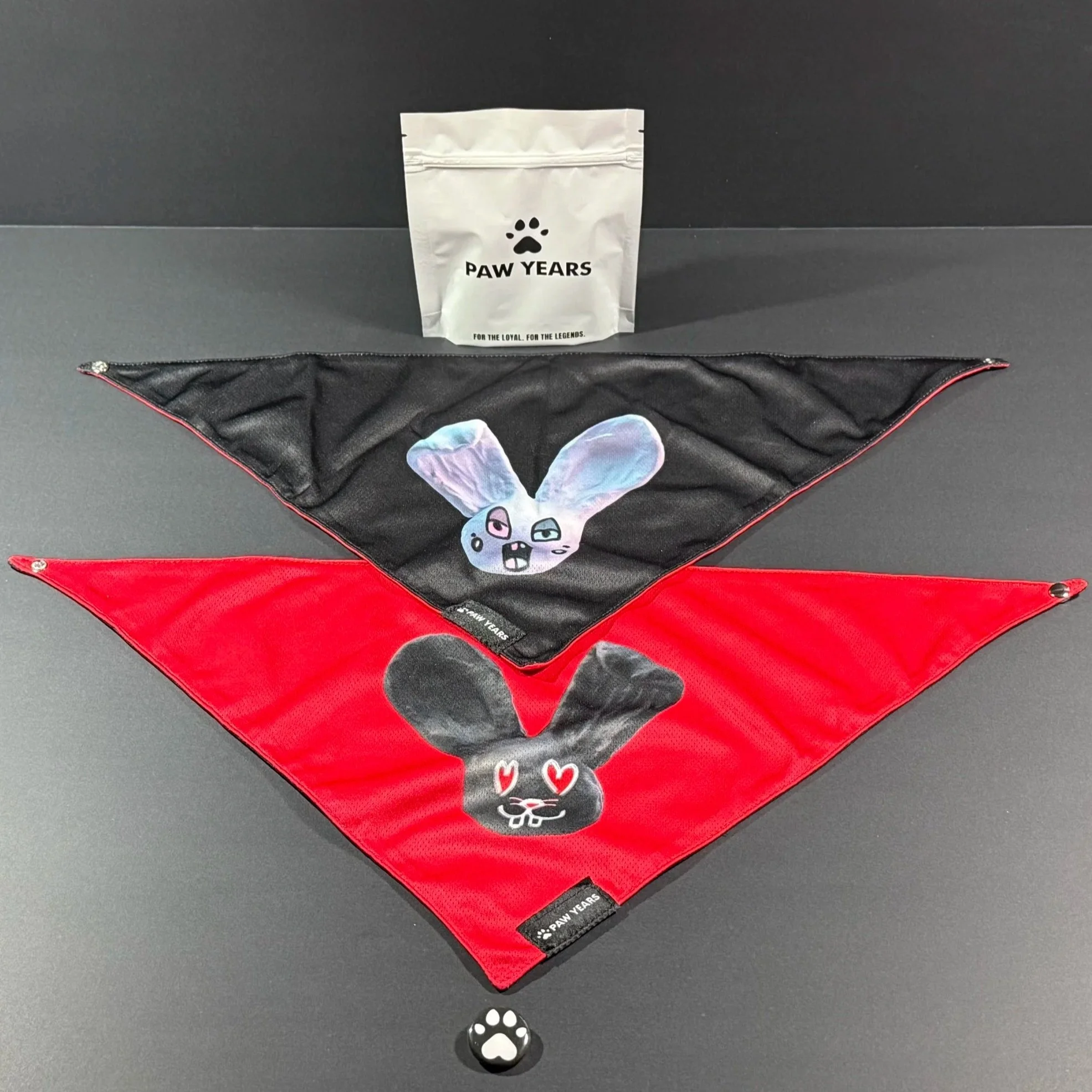 Paw Years reversible bandana set showing both the black Loopy design and red Lovestruck design with packaging.