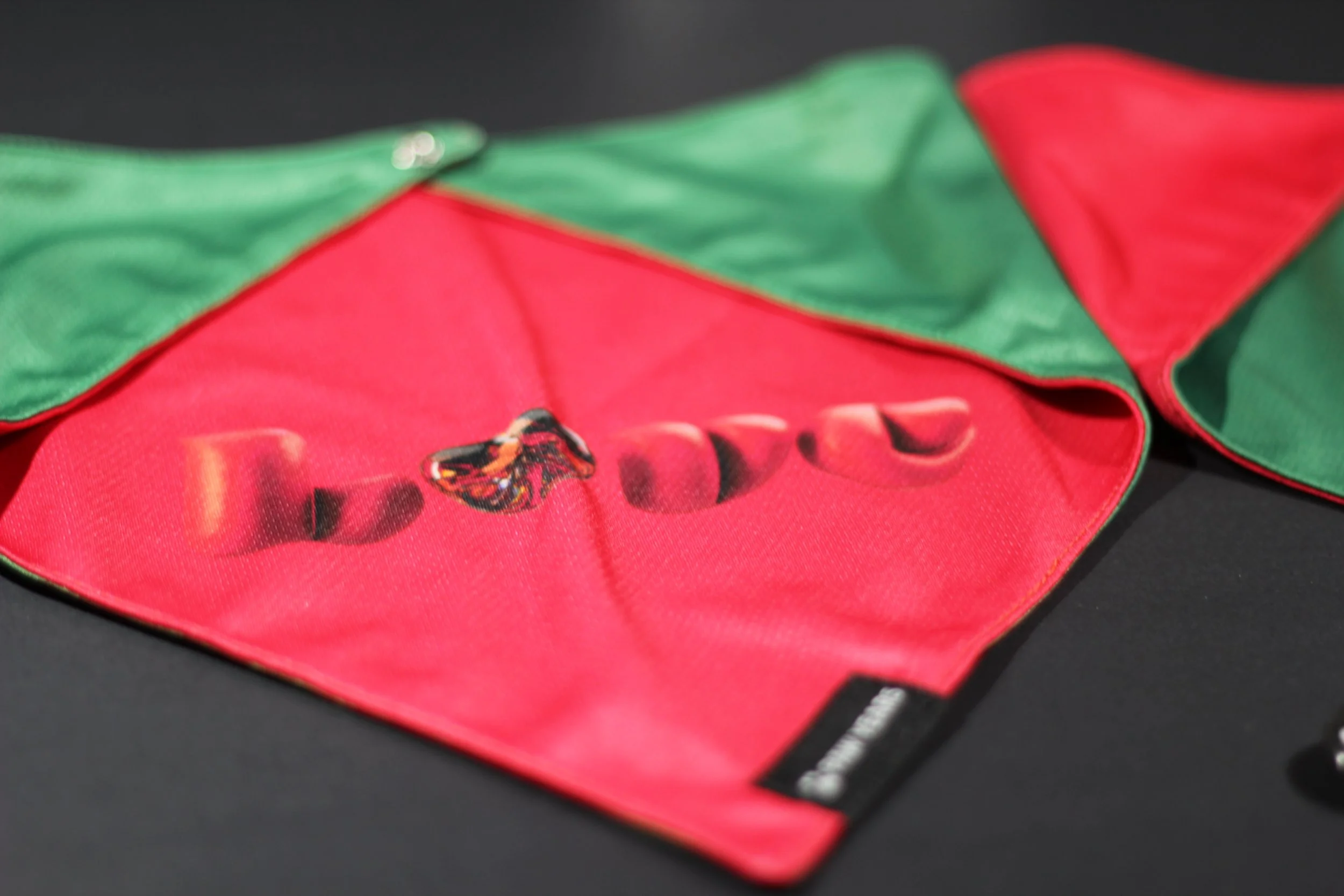 Detail shot showing reversible construction of Winter Love pet gear with both green snowman and red heart designs visible.