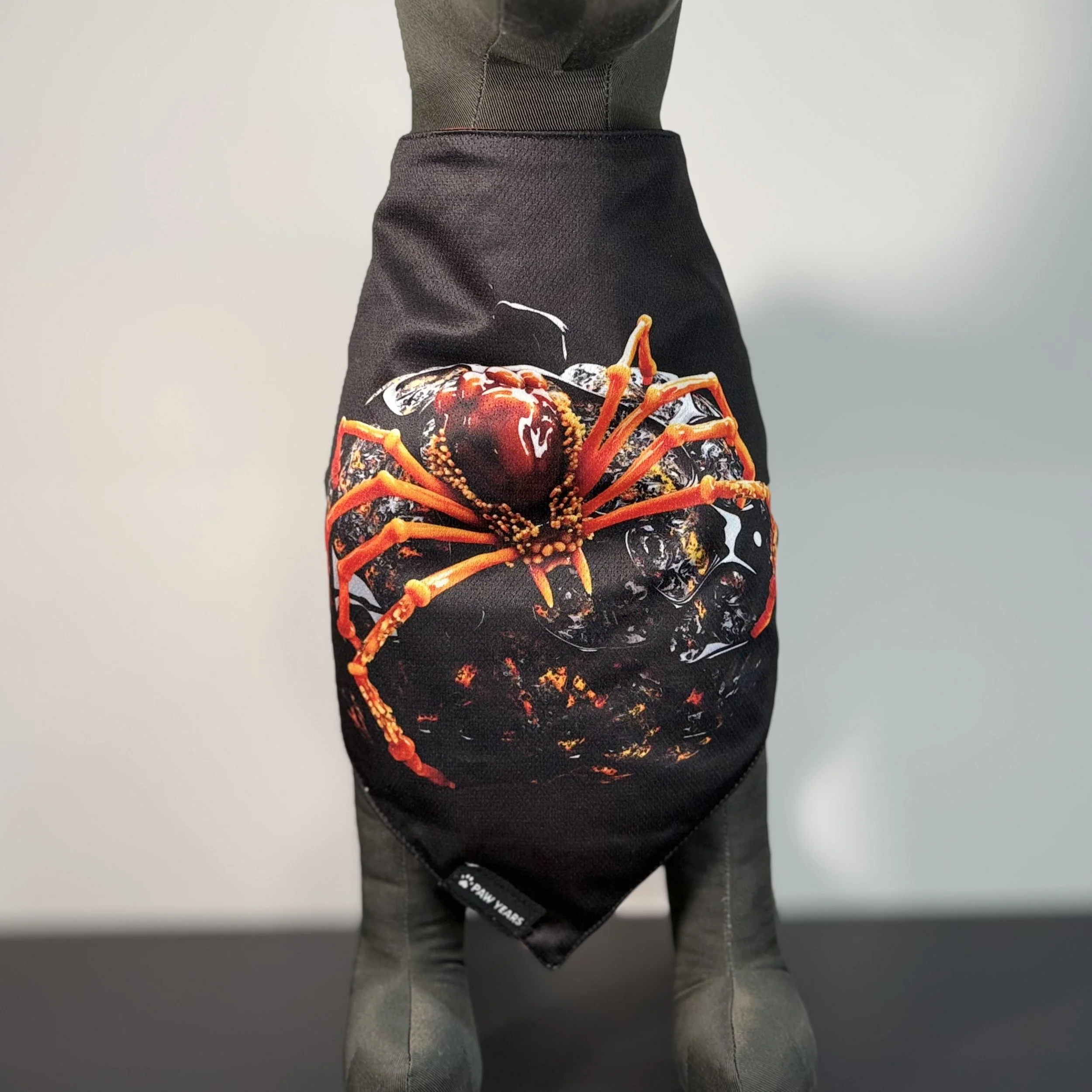 Front view of dog mannequin wearing black Banshee bandana featuring large red and orange spider art.