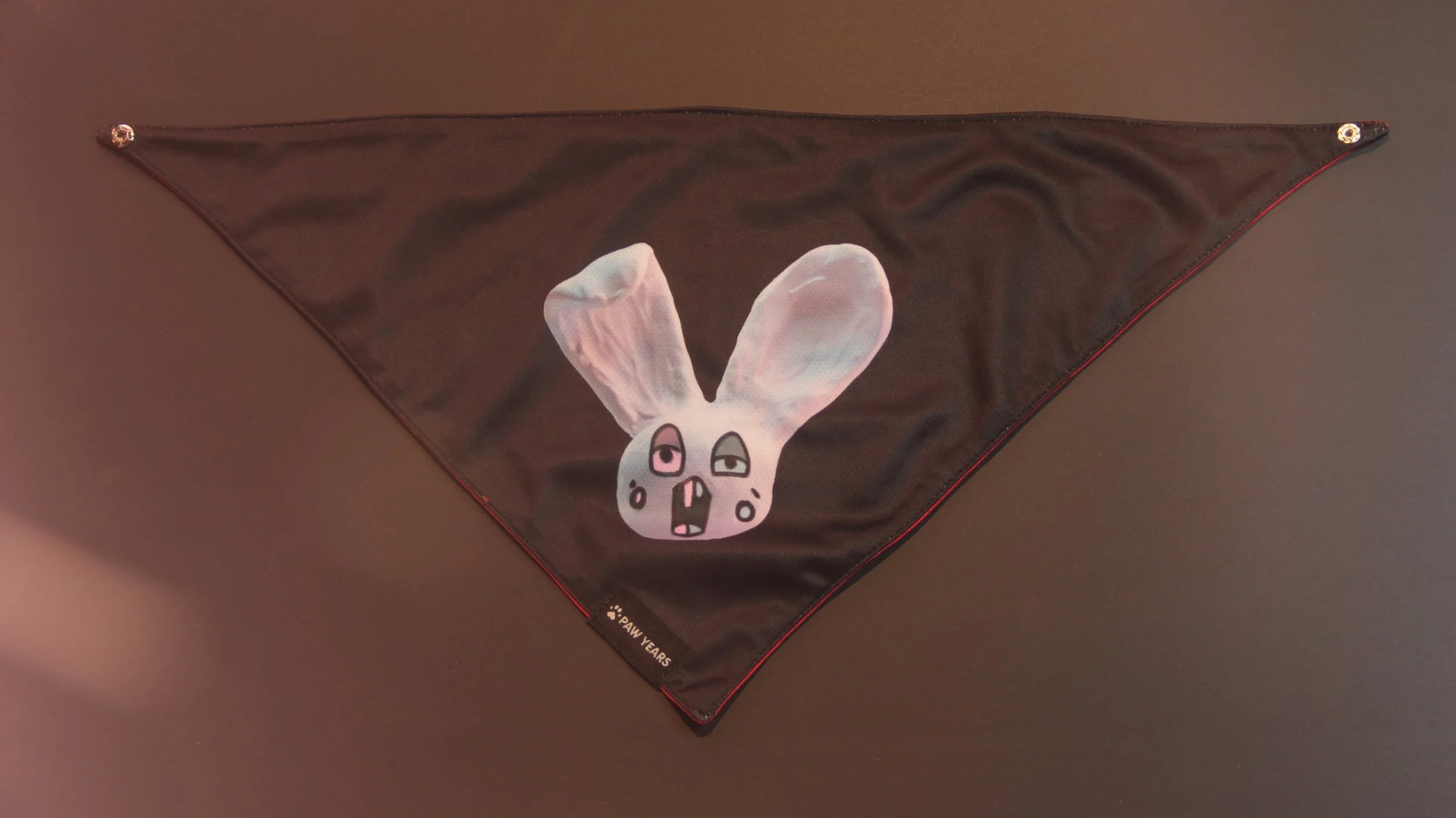 Flat lay of the black Loopy bandana featuring a blue dazed bunny.