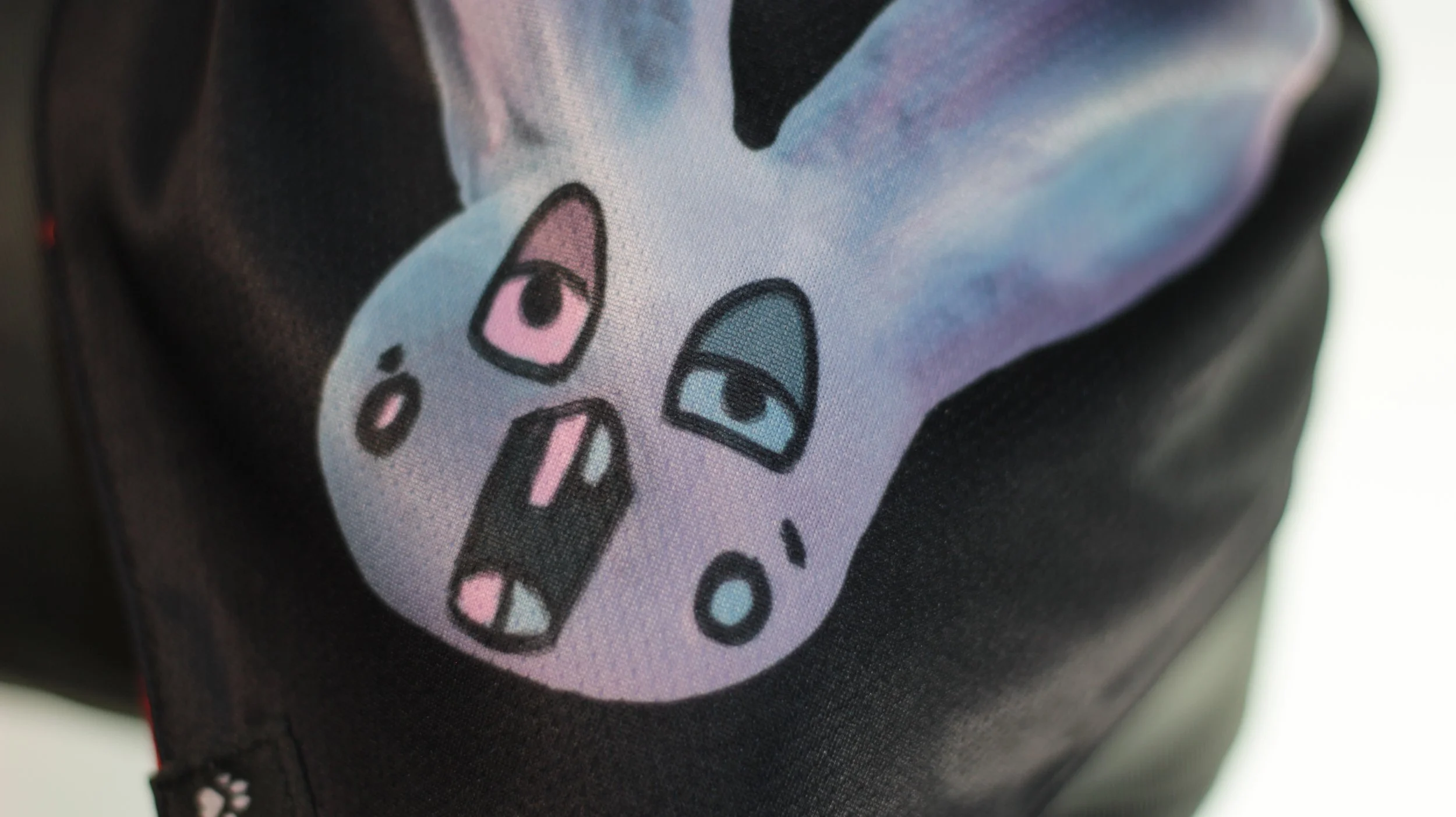 Close up detail of the Loopy blue bunny face on black mesh fabric.