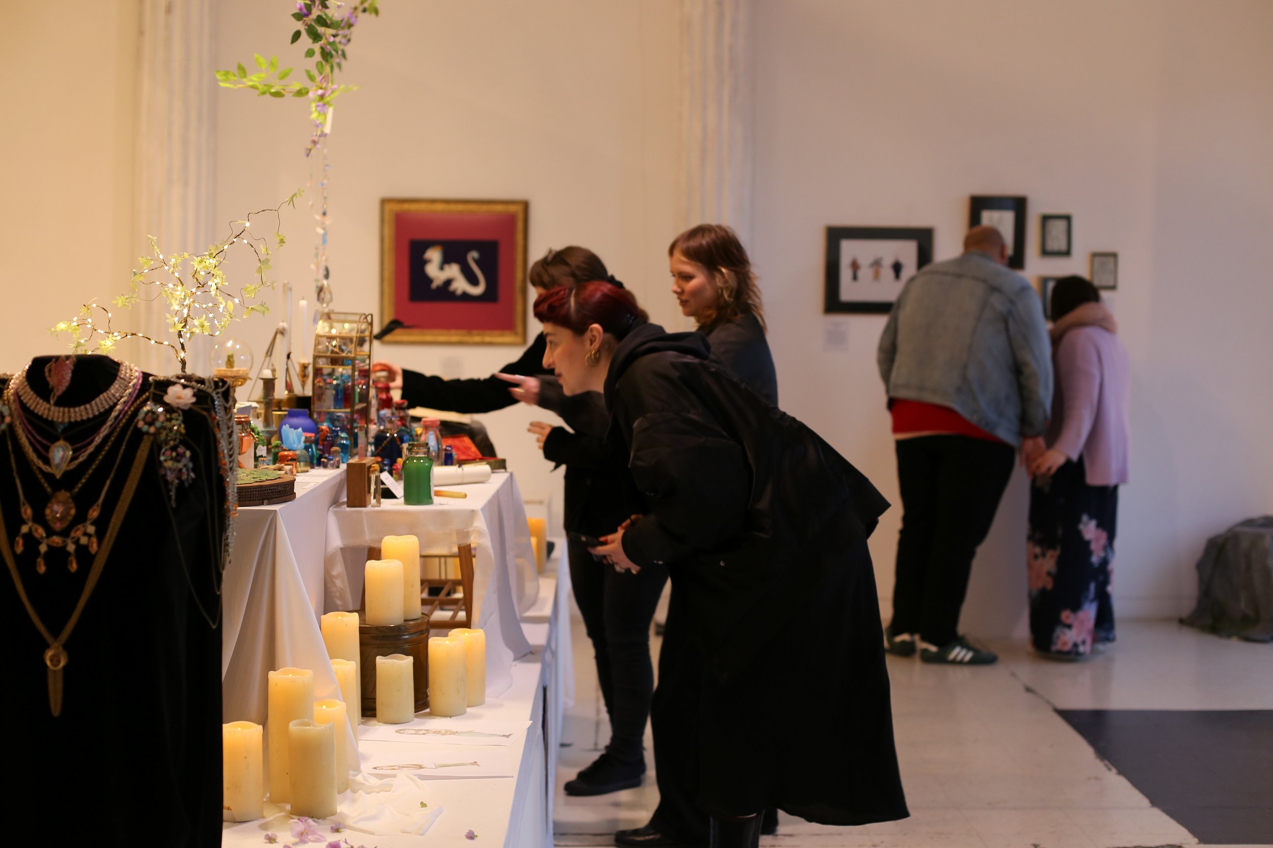 People browsing potions at an art exhibit.