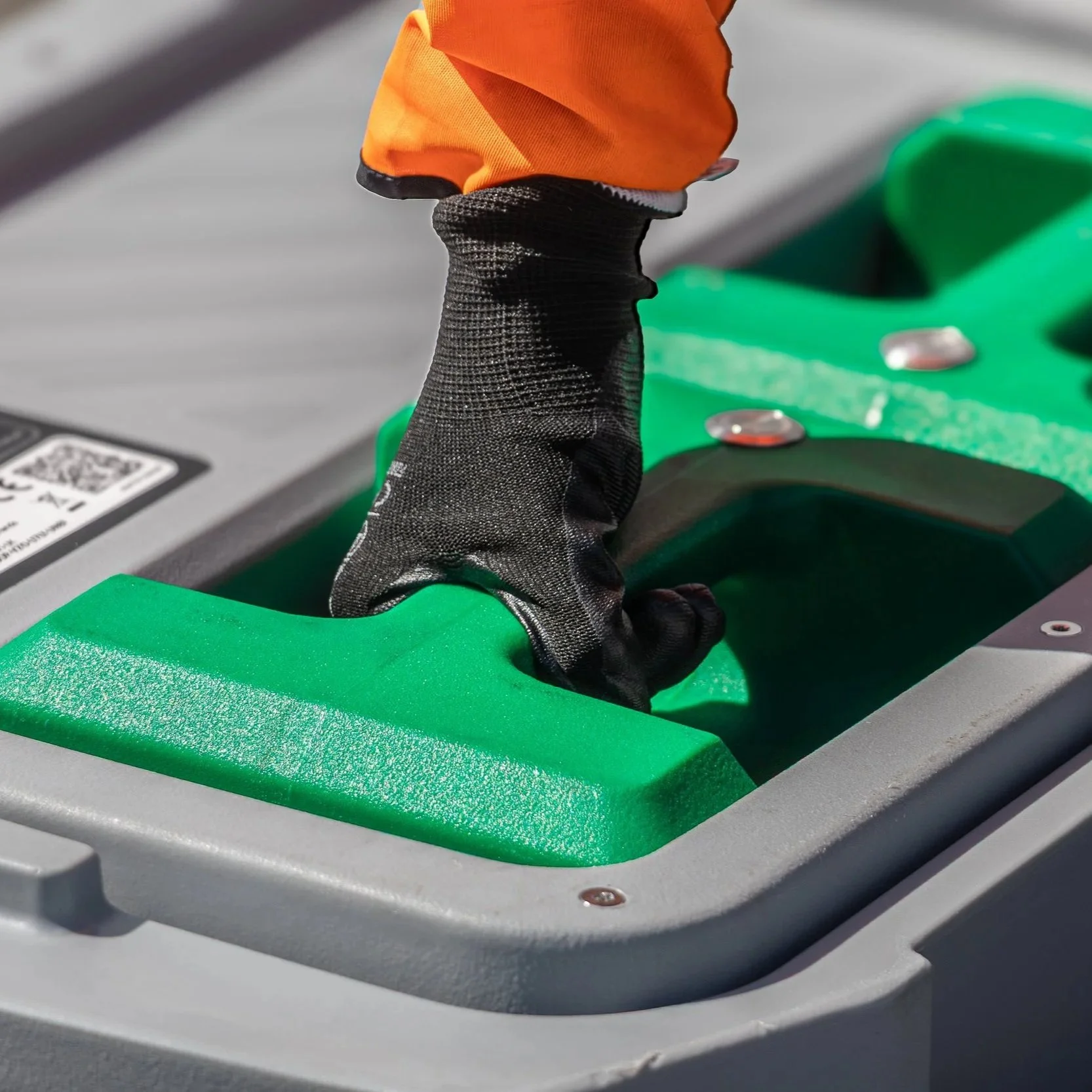 A person holding a large green battery pack next to a smaller green battery pack, both placed on a black Renset battery management system device.