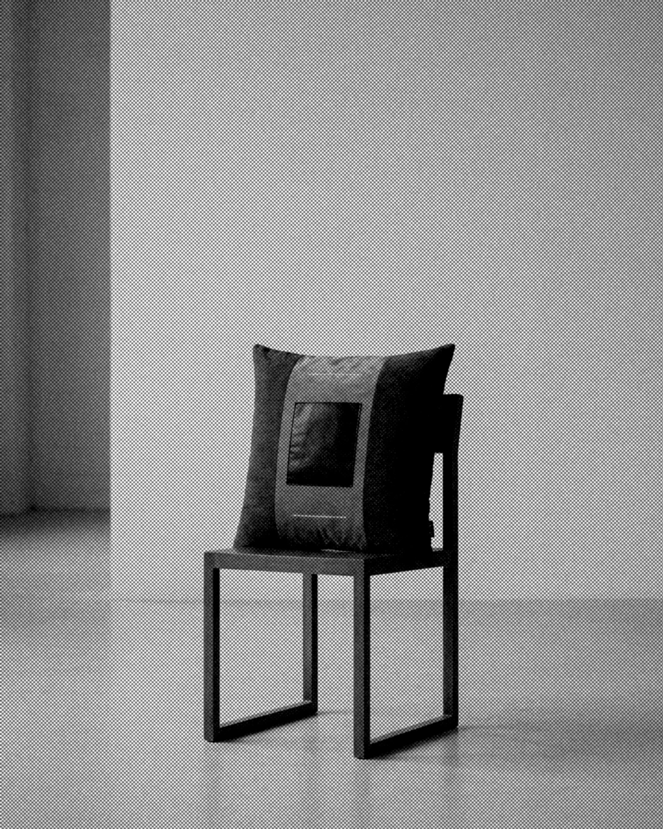 CUADRO was developed around the placement of a single black leather square within a constructed textile field. The central panel is framed by contrasting upholstery fabrics, with two embroidered lines extending the geometry of the composition.

Acros