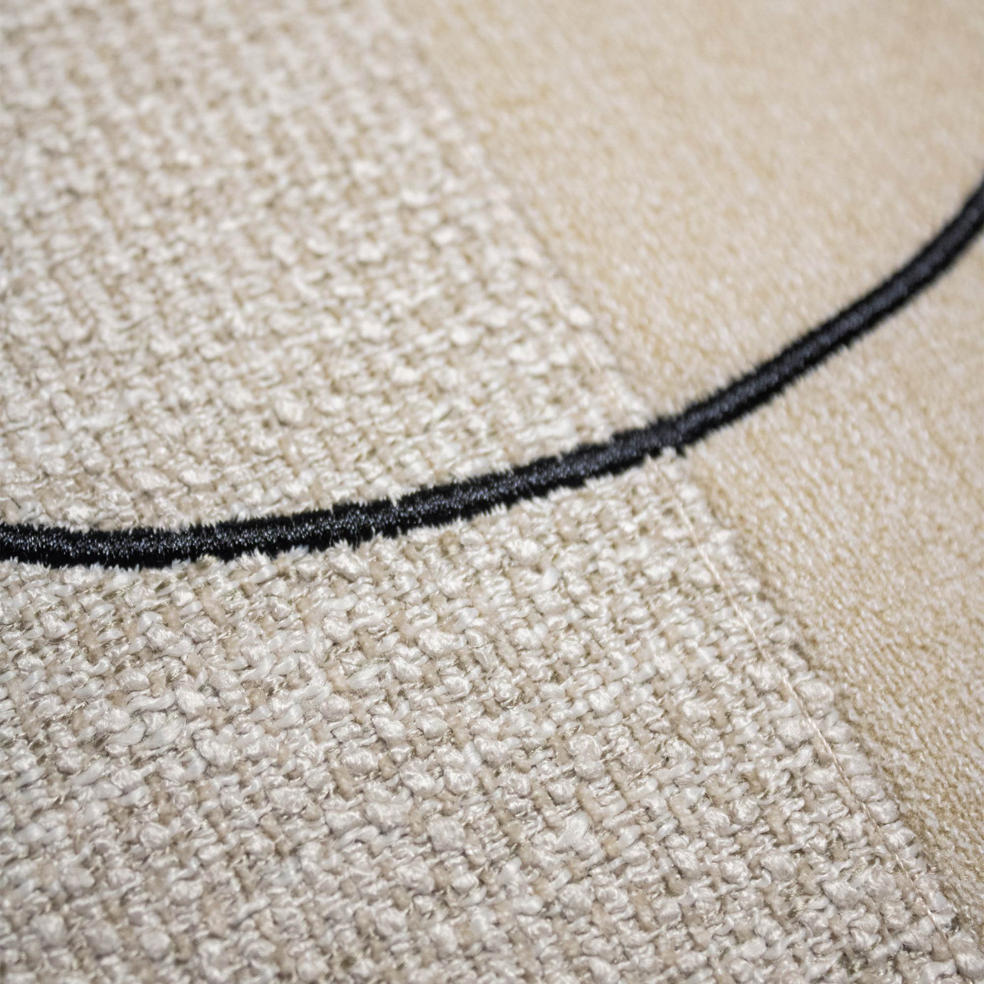 LUAR_03 decorative cushion in beige and cream textile with central black circular embroidery detail
