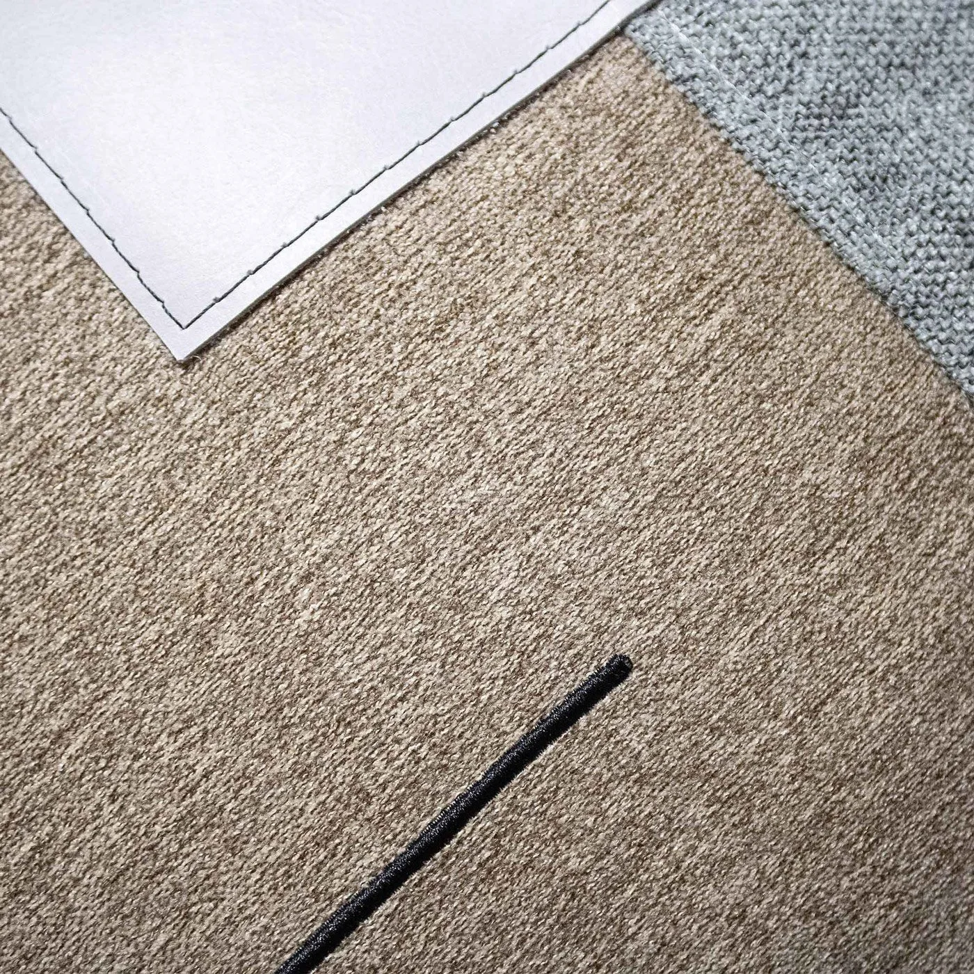 ELAMA_01 decorative cushion in brown and grey textile with central light grey leather panel and black stitched line detail