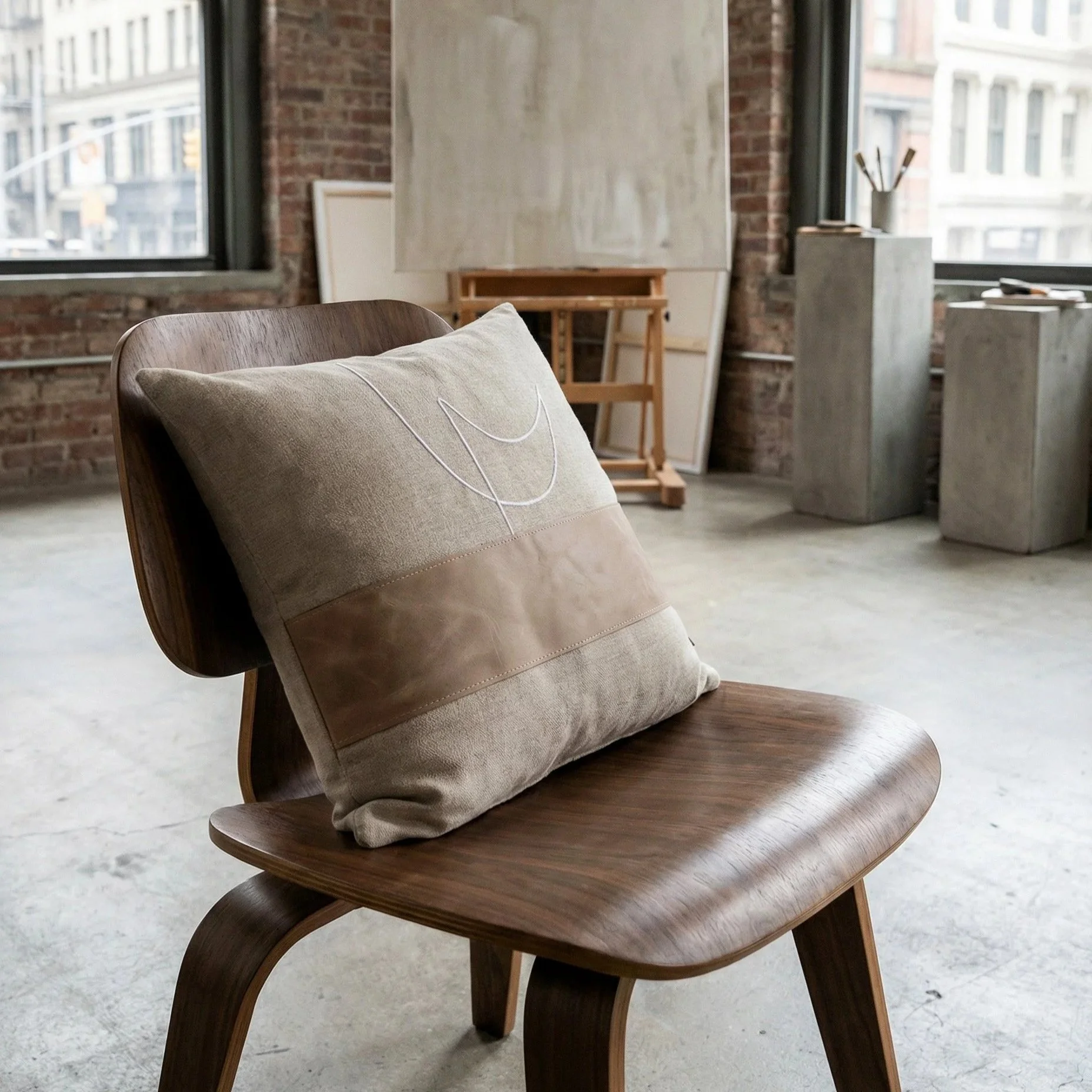 pillow+RAIO_02+naturally+placed+on+a+dark+wood+modern+chair+with+angled+view+%281%29.jpg