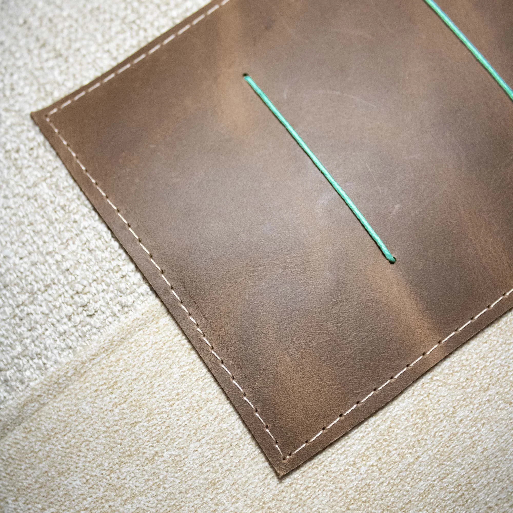 NASARA_03 decorative cushion in beige textile with brown leather panel and vertical seafoam stitched detail