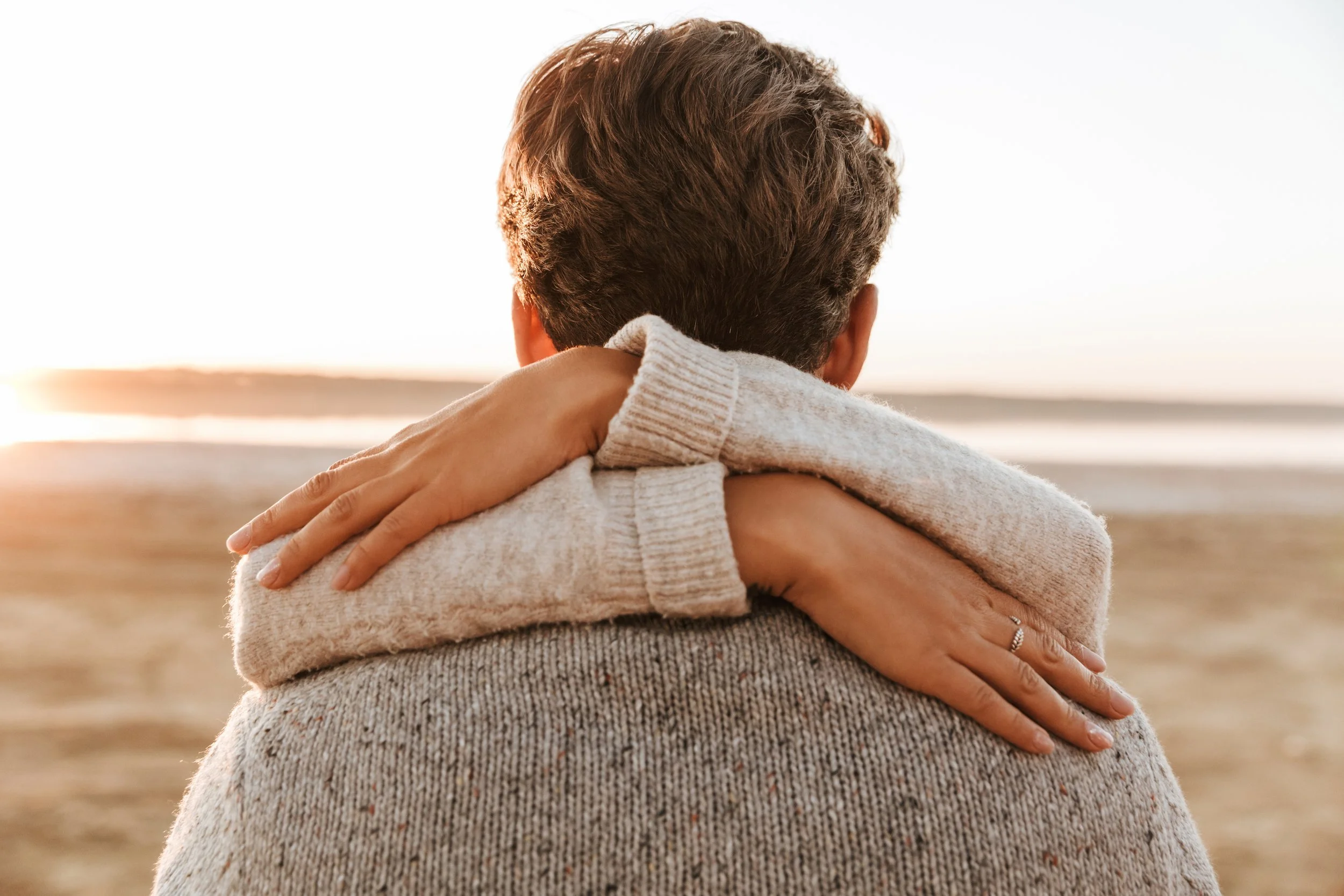 “Couple connecting through a simple, affectionate moment on the beach at sunset”
