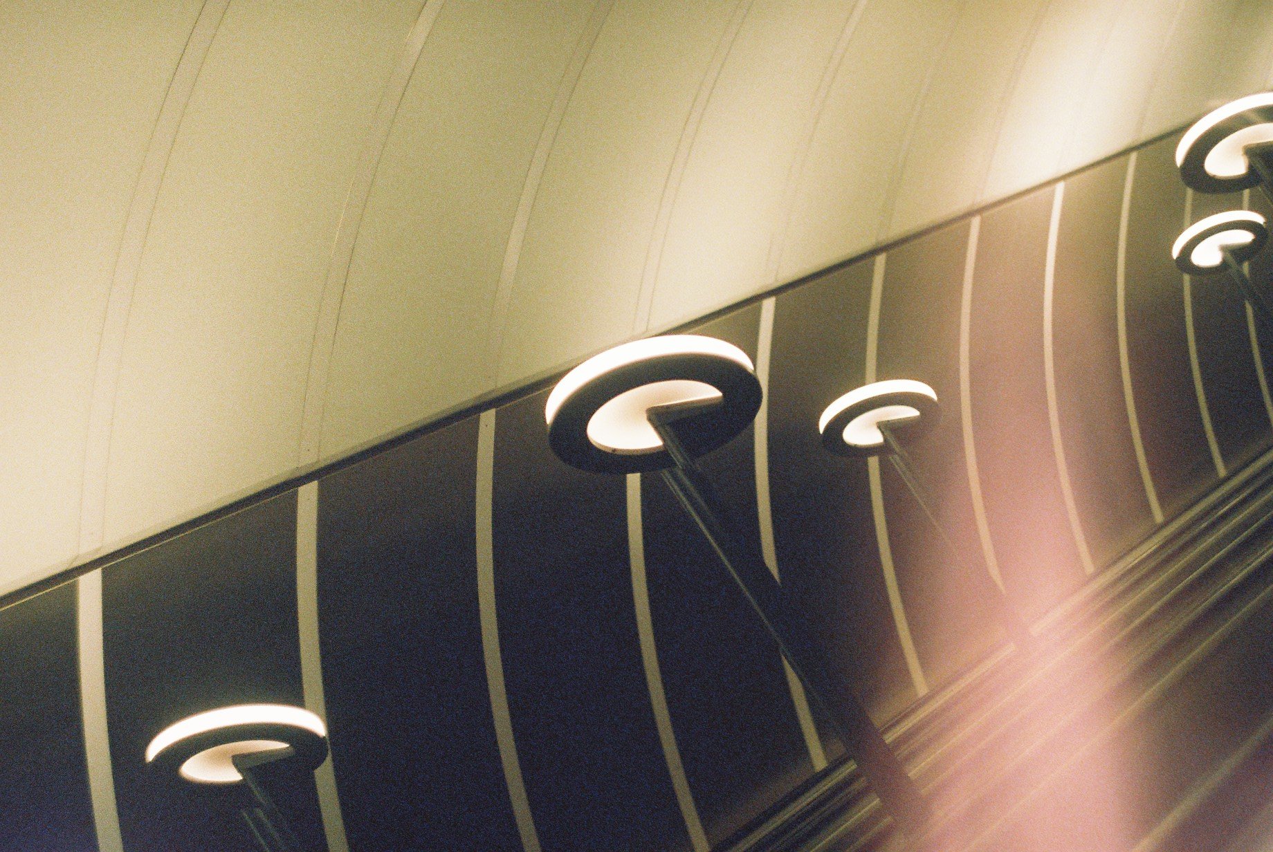 Close-up view of illuminated circular lights mounted on a ceiling with a striped pattern.