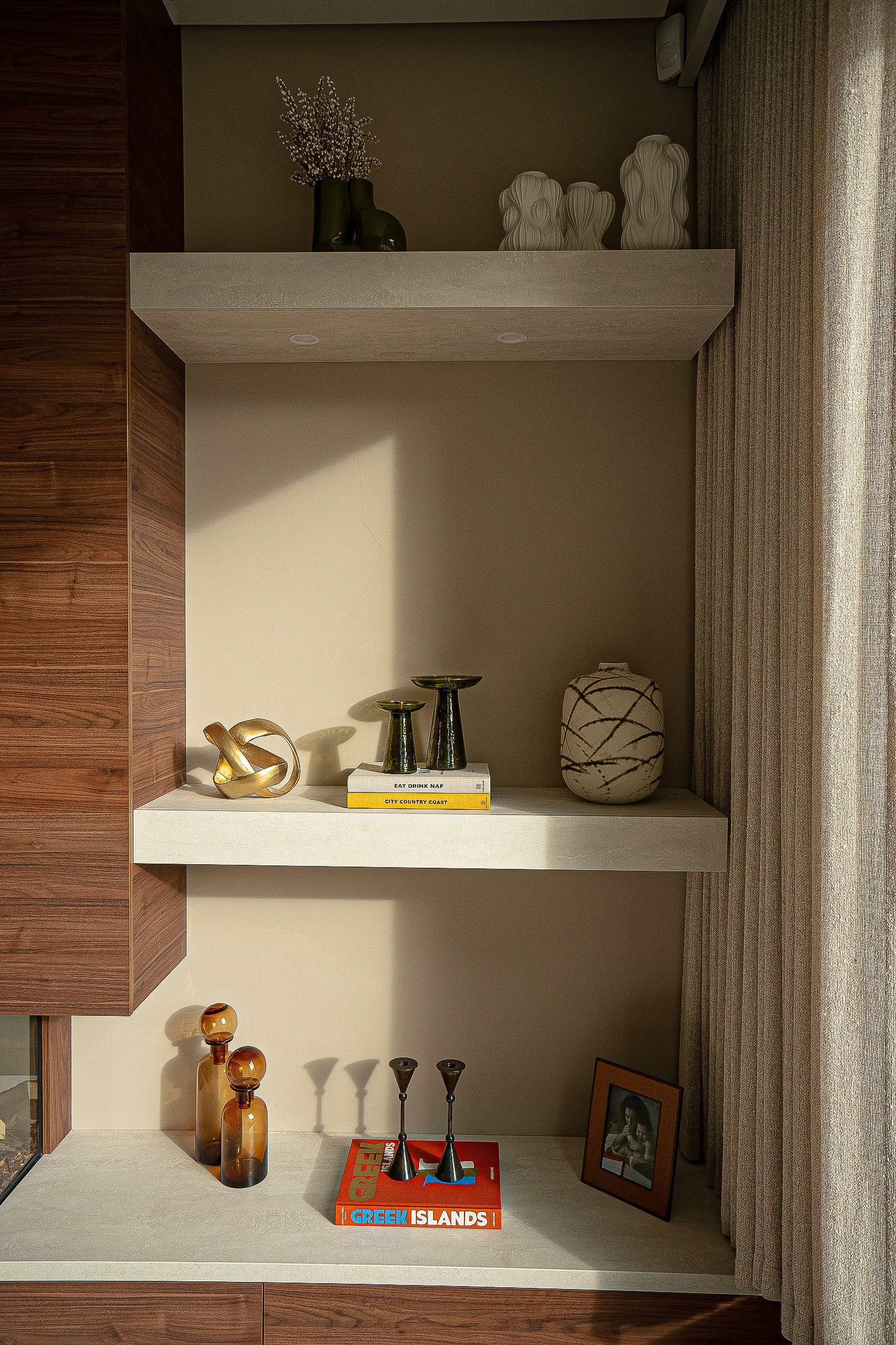 Contemporary living room shelves with decorative items, including books, vases, candlesticks, and ornaments.