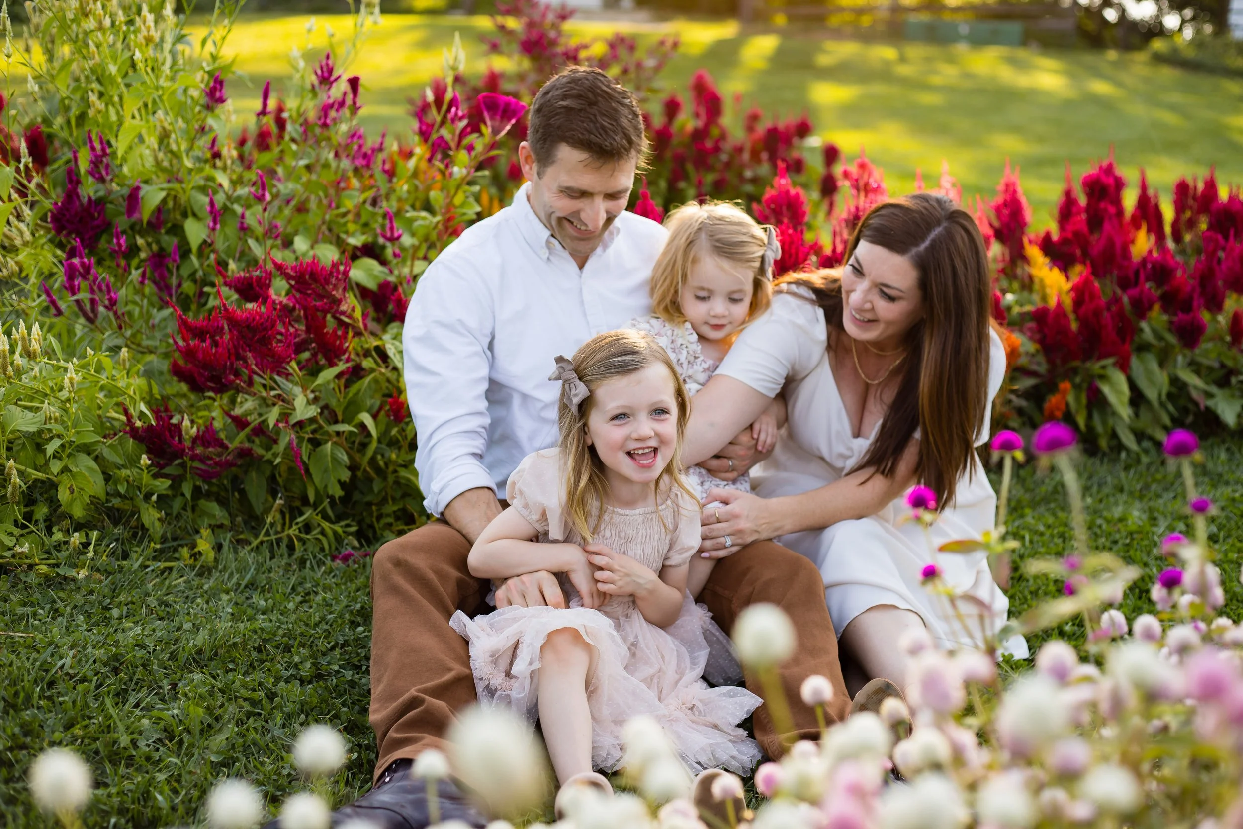family in a wildflower farm enjoying a cool Sumer day while laughing and playing.