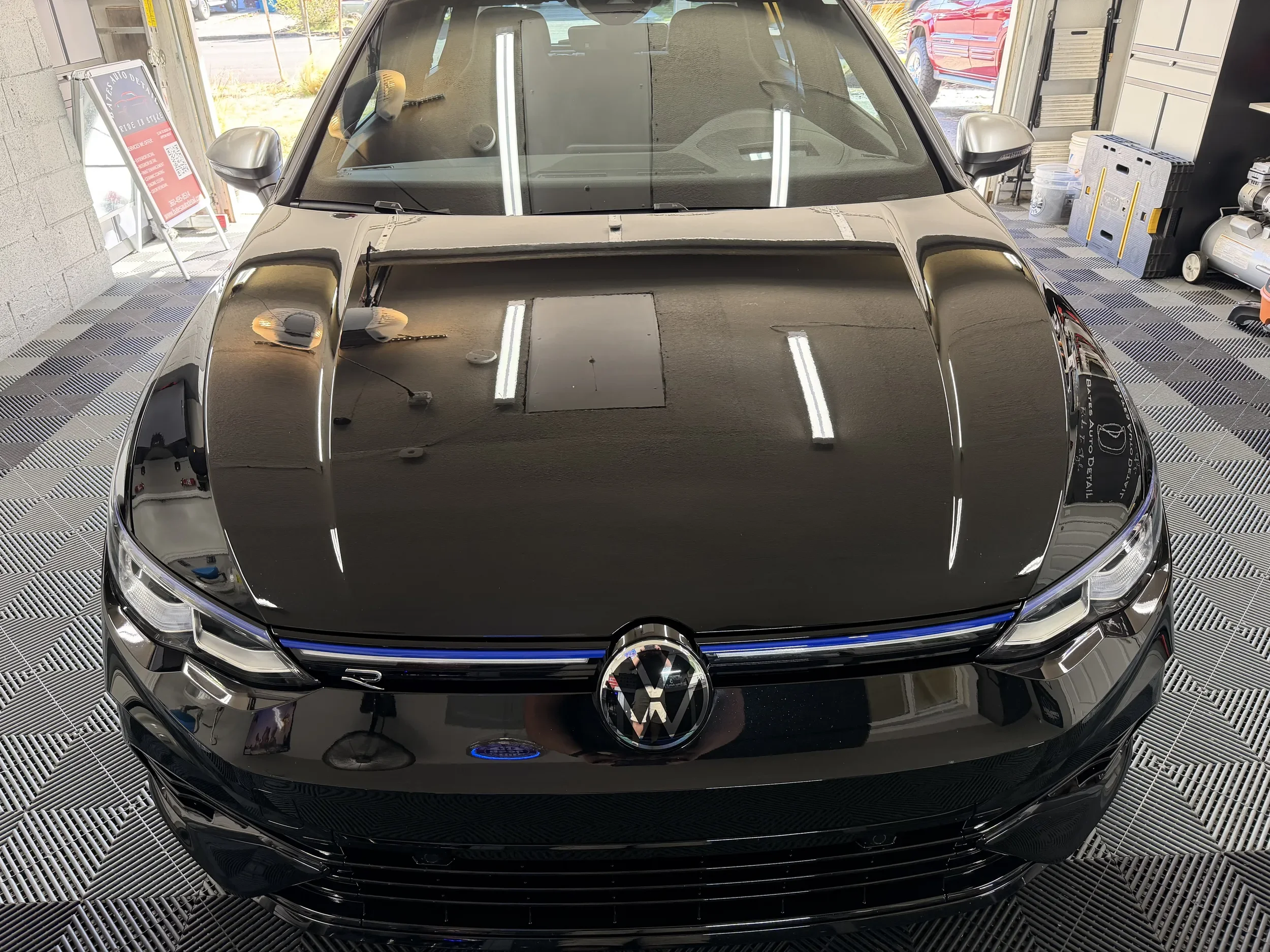 Front view of a black Volkswagen Golf with a polished finish after detailing.