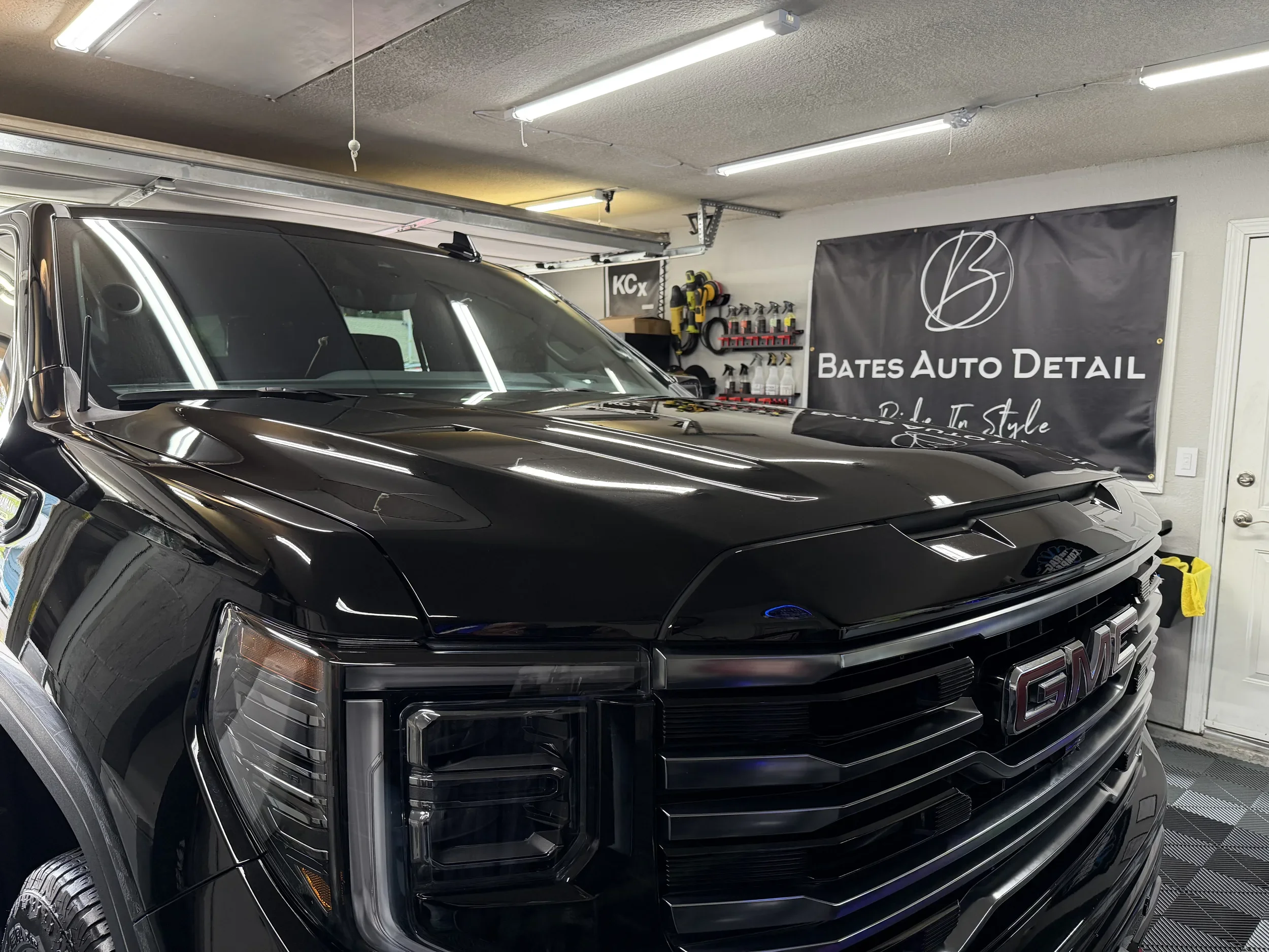 Close front view of a black GMC Sierra after exterior detailing.