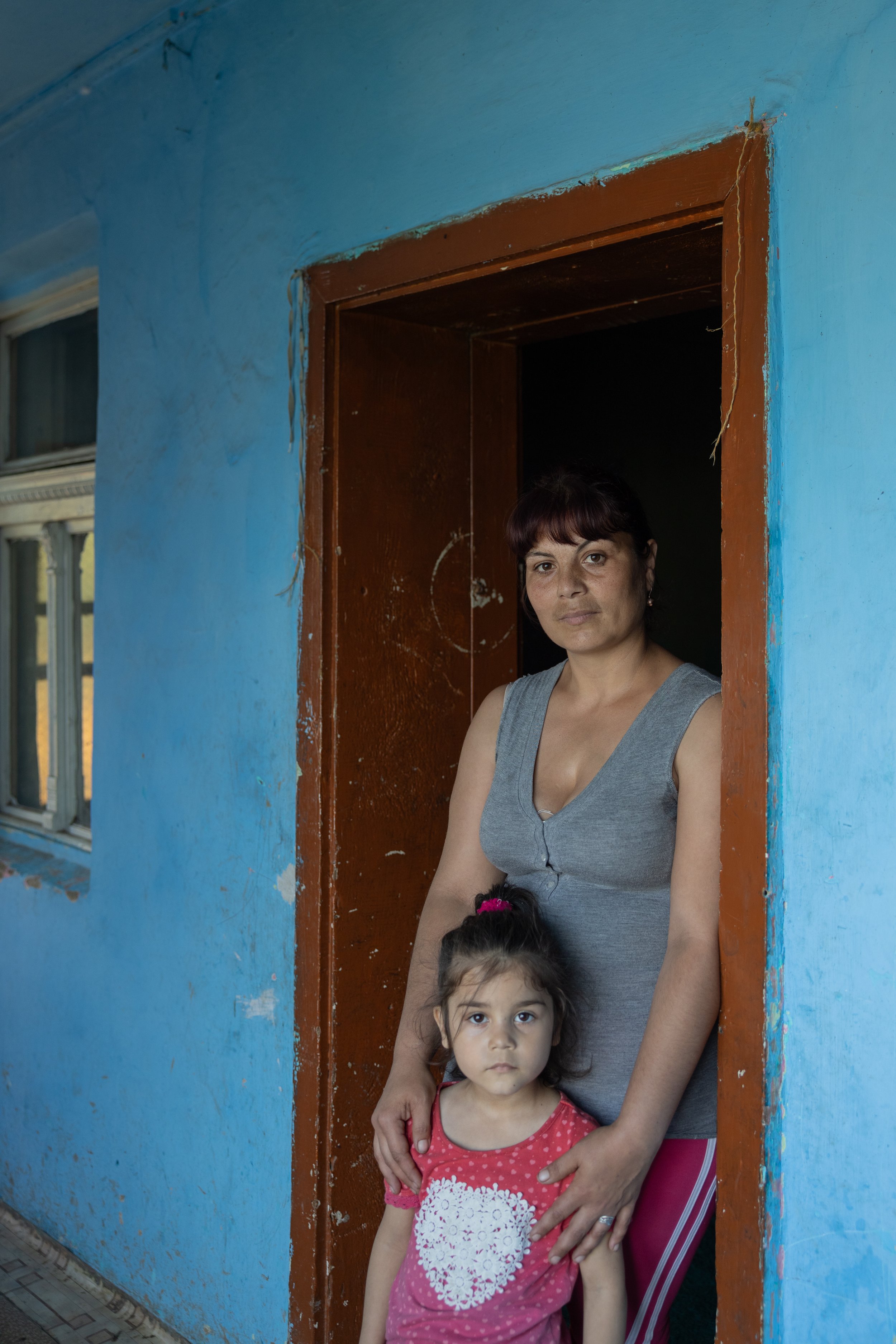 Olena stands with her daughter at their front door.jpg
