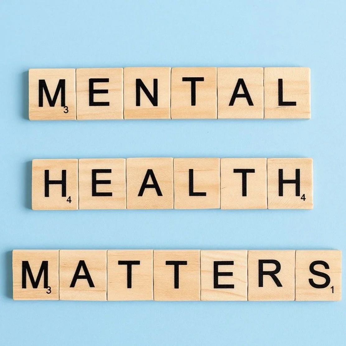 Scrabble tiles spelling out 'MENTAL HEALTH MATTERS' on a blue background.