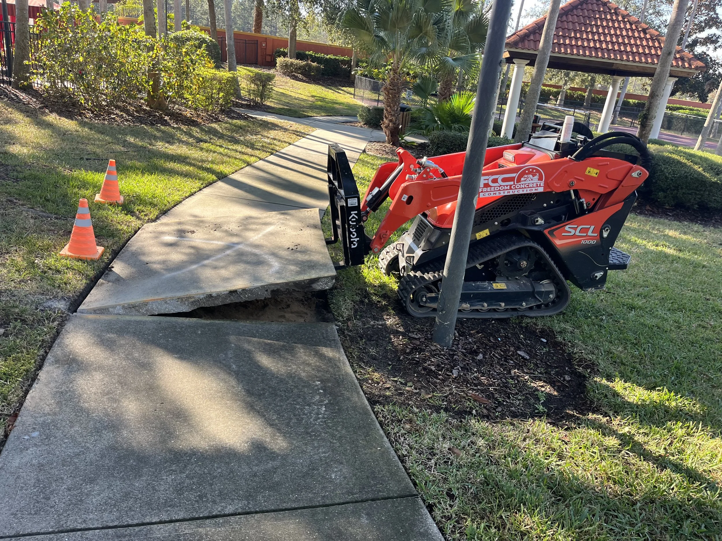 Freedom Concrete Construction Kubota mini track loader removing concrete slab in Davenport FL