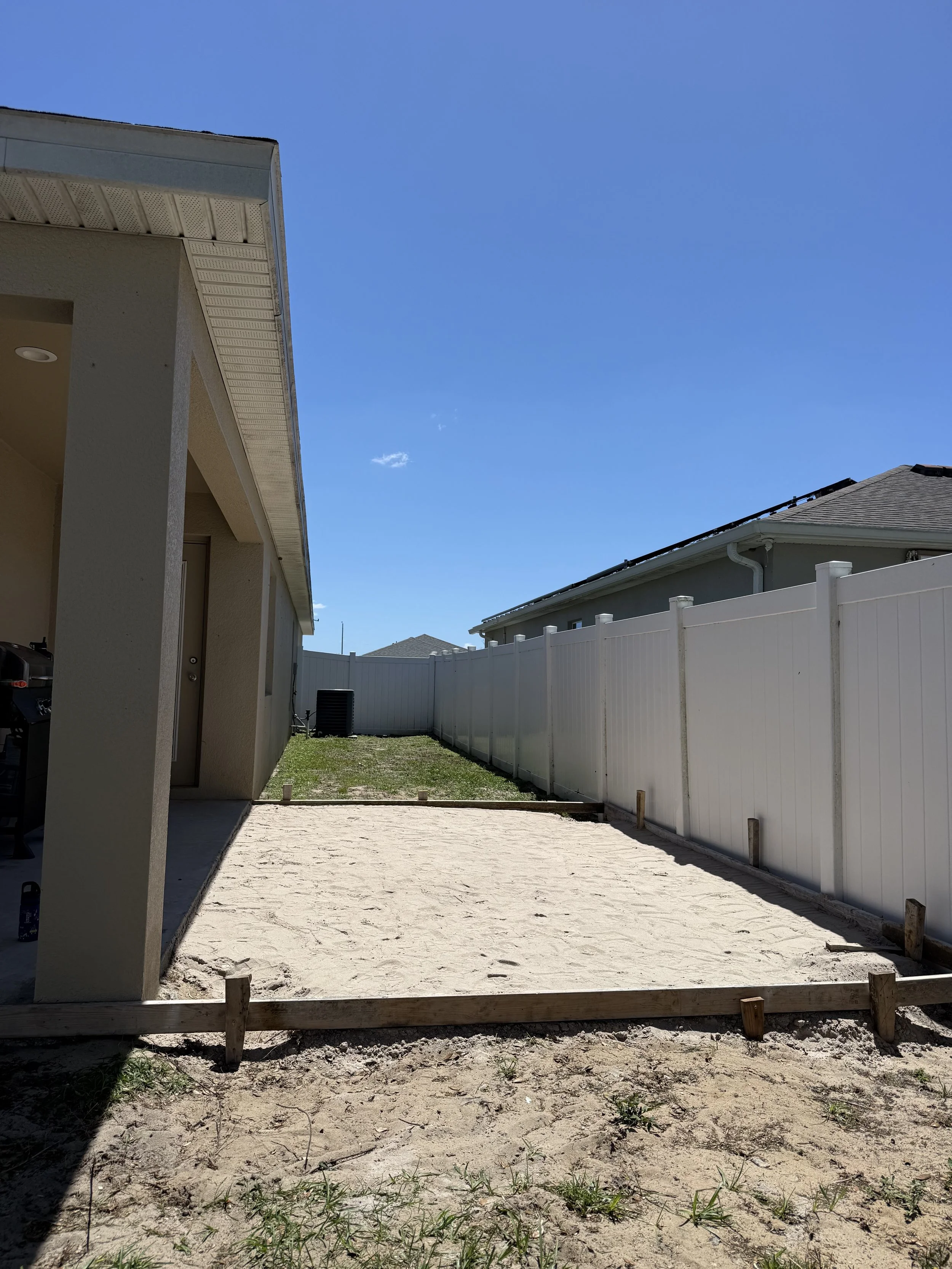 Framed patio extension site prep with compacted sand sub-base
