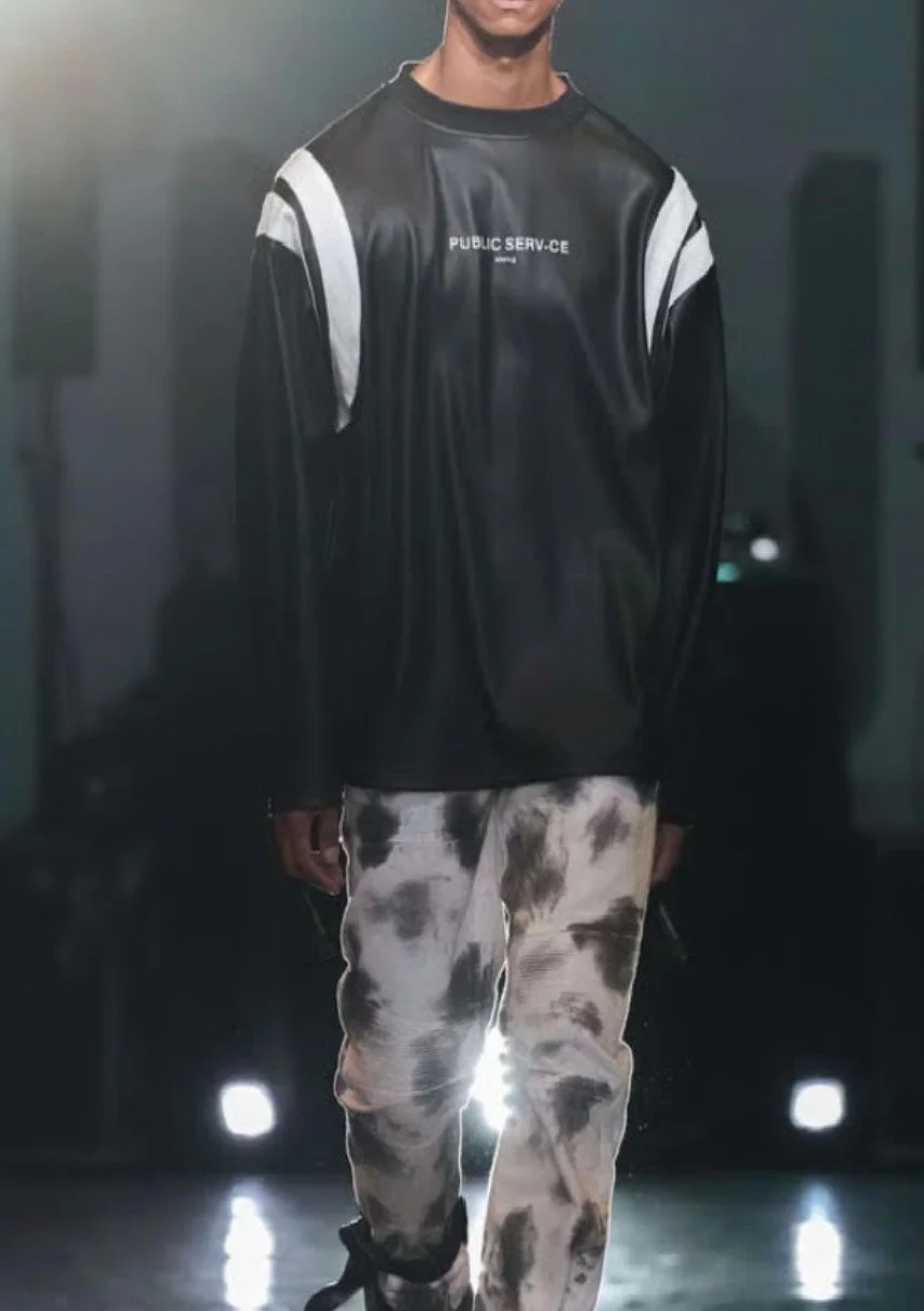 Model on the runway in Raphael Young's The Rest Is Noise SS27 collection for House of Public Serv-ce at New York Fashion Week model wearing leather sweatshirt