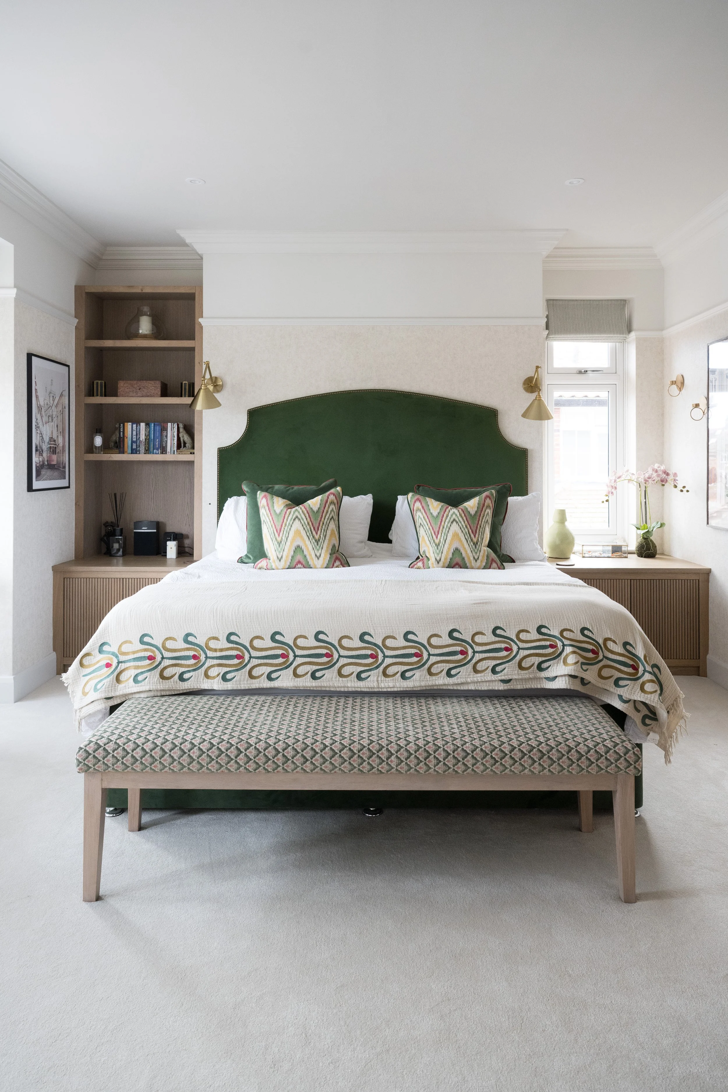 Elegant bedroom designed by StyleSmith Interiors with a bespoke green upholstered headboard, fitted shelving and soft neutral décor in Harrogate