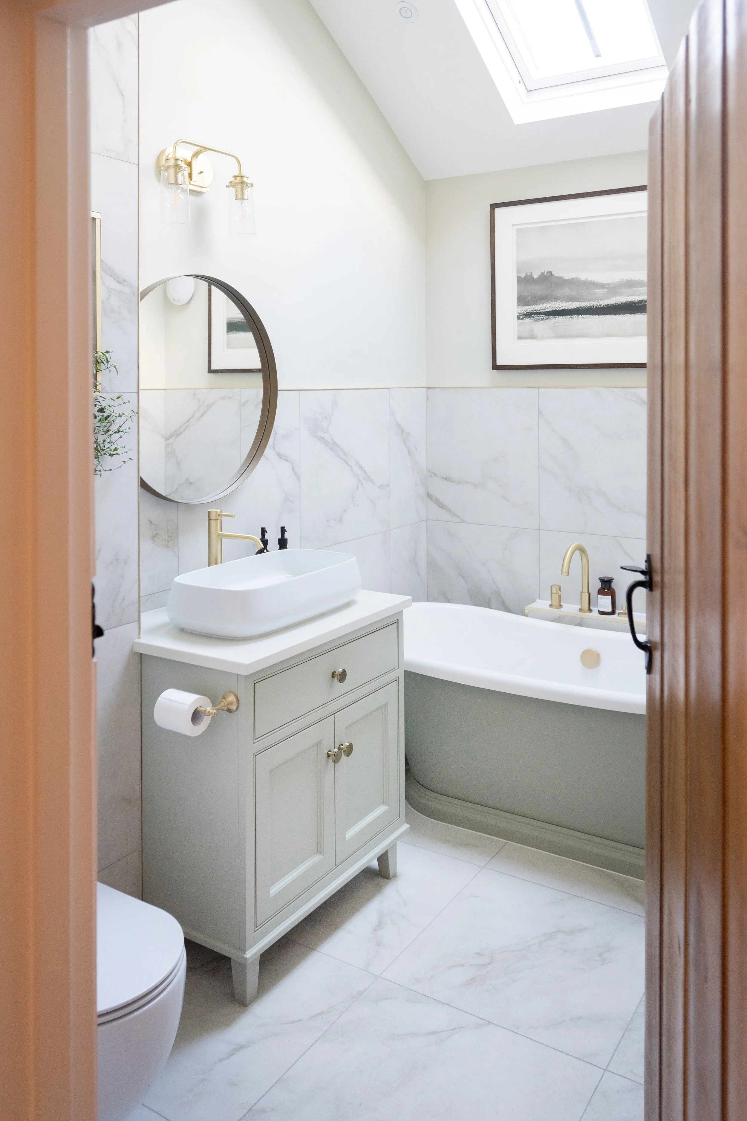 Elegant family bathroom by StyleSmith Interiors with a bespoke painted vanity, freestanding bath, marble-effect wall tiles and brushed brass fixtures in a Yorkshire home