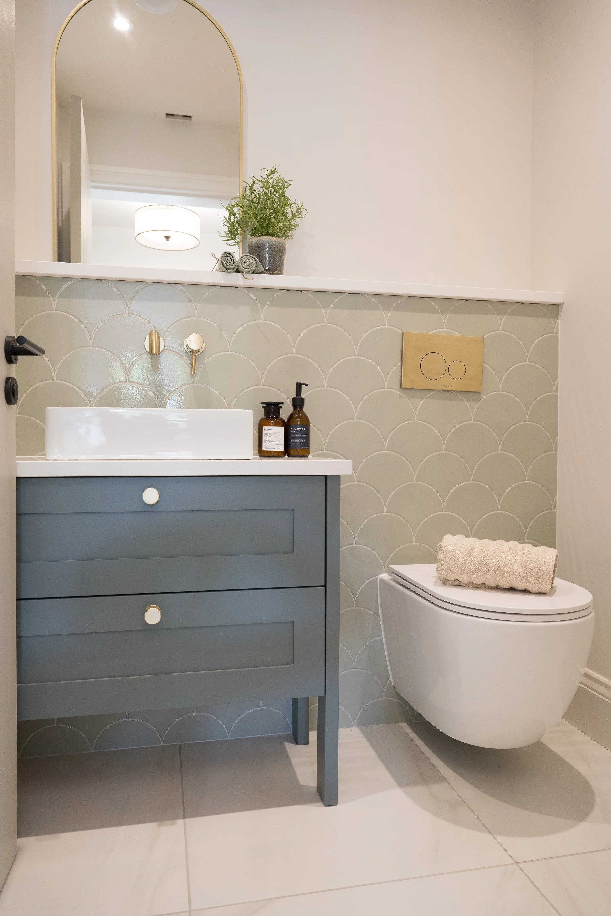 Contemporary bathroom designed by StyleSmith Interiors featuring a painted vanity unit, scallop wall tiles, wall-mounted basin and brushed brass fittings in a Harrogate home