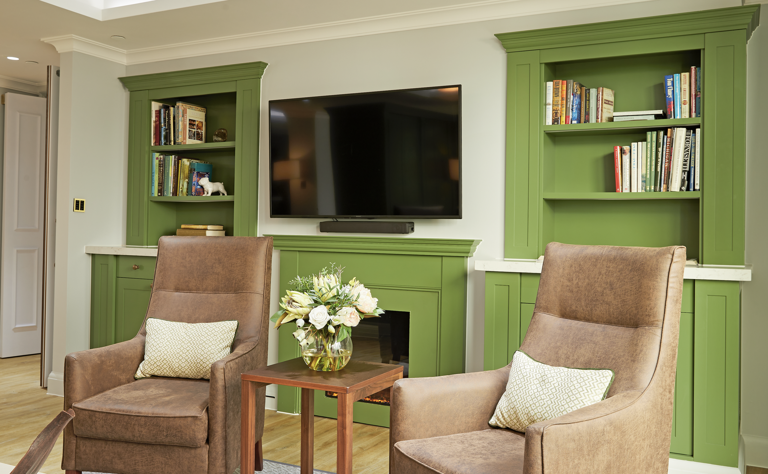 Comfortable care home residents' lounge designed by StyleSmith Interiors with bespoke cabinetry, feature fireplace and inviting seating area