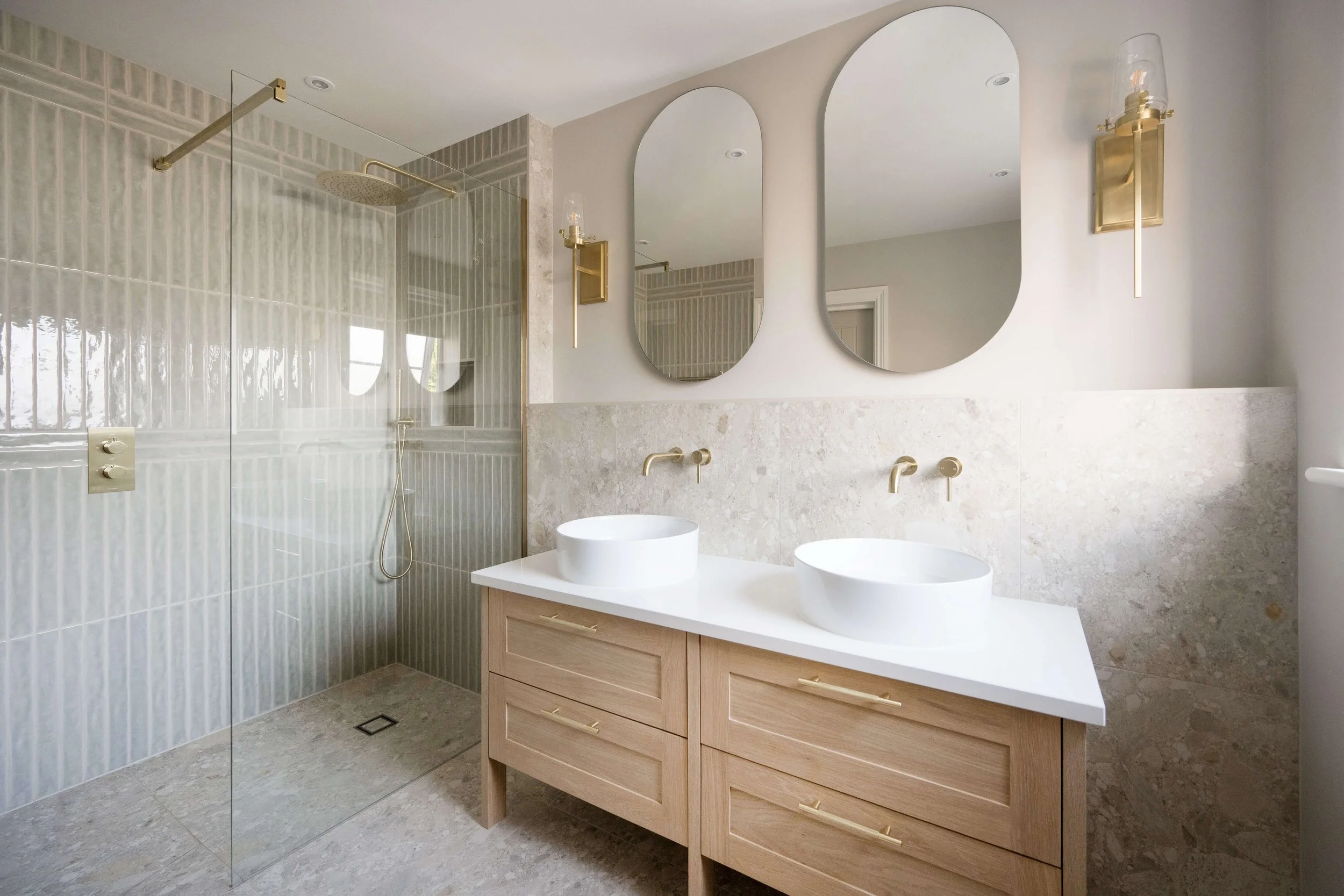 Luxury bathroom designed by StyleSmith Interiors featuring a double oak vanity, twin basins, brass fittings and a walk-in shower Harrogate Interior Design Studio