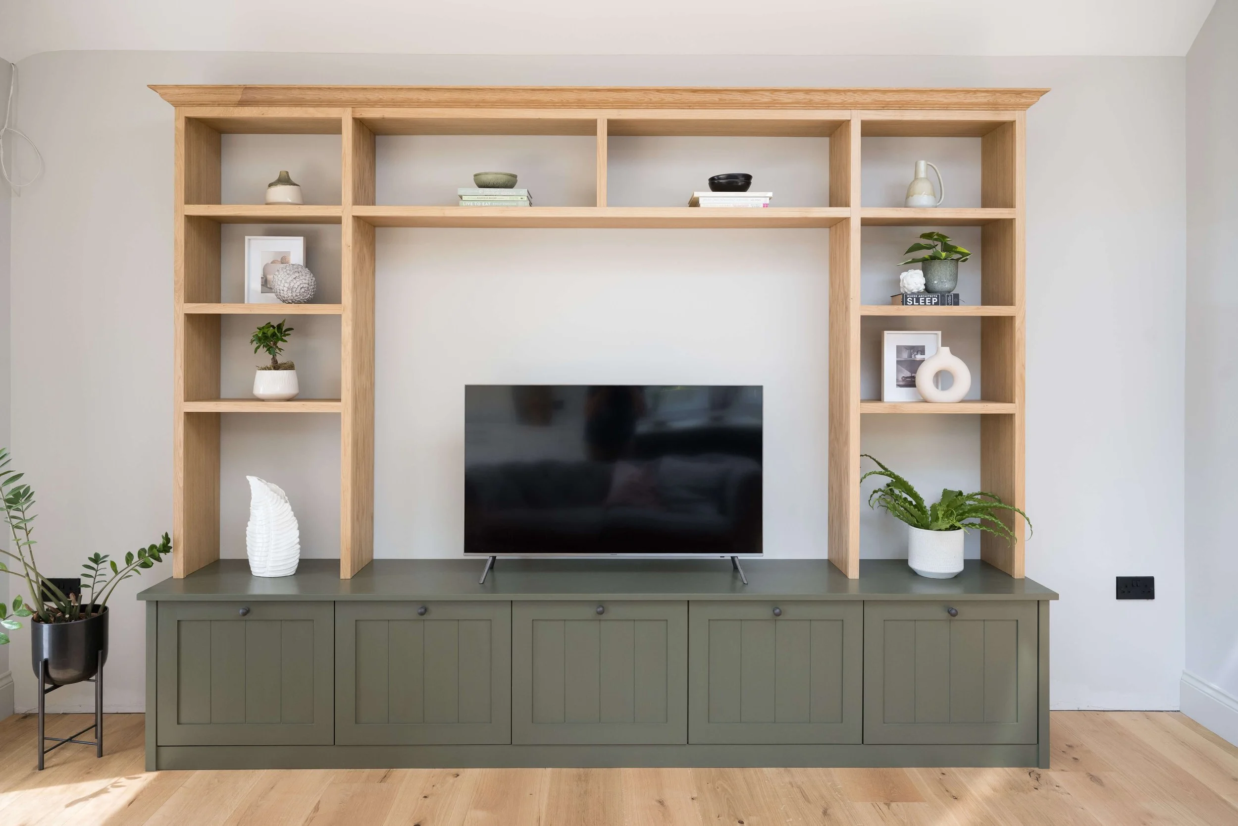 Bespoke oak media wall with built-in shelving in a contemporary living room by StyleSmith Interiors, Harrogate interior designers serving Yorkshire