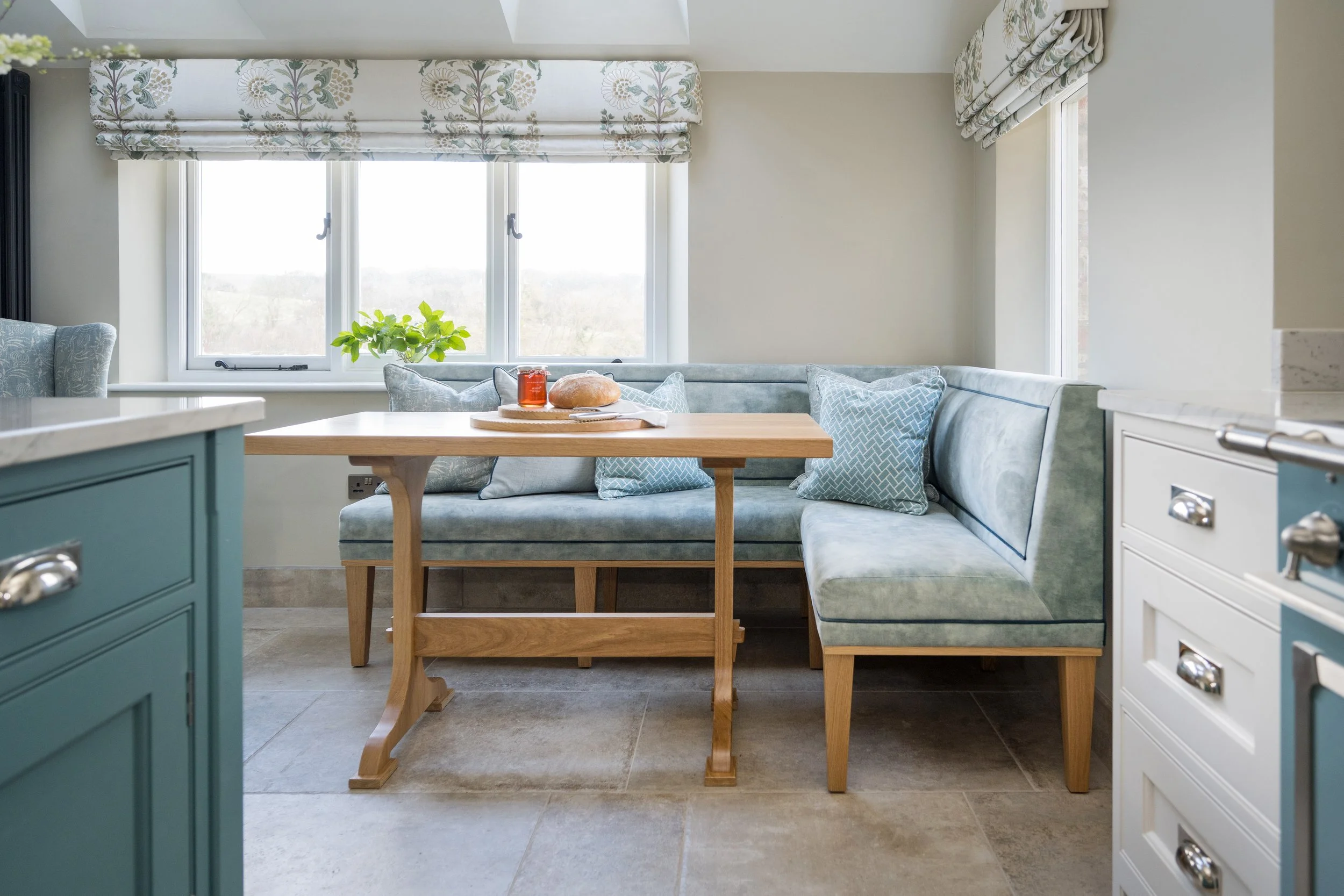 Custom breakfast nook with upholstered banquette seating, oak dining table and soft neutral styling designed by StyleSmith Interiors in Yorkshire