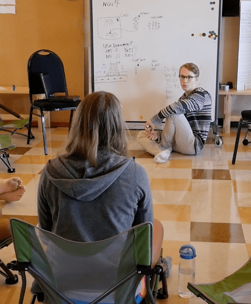 Acton boy sitting in front of white board.png