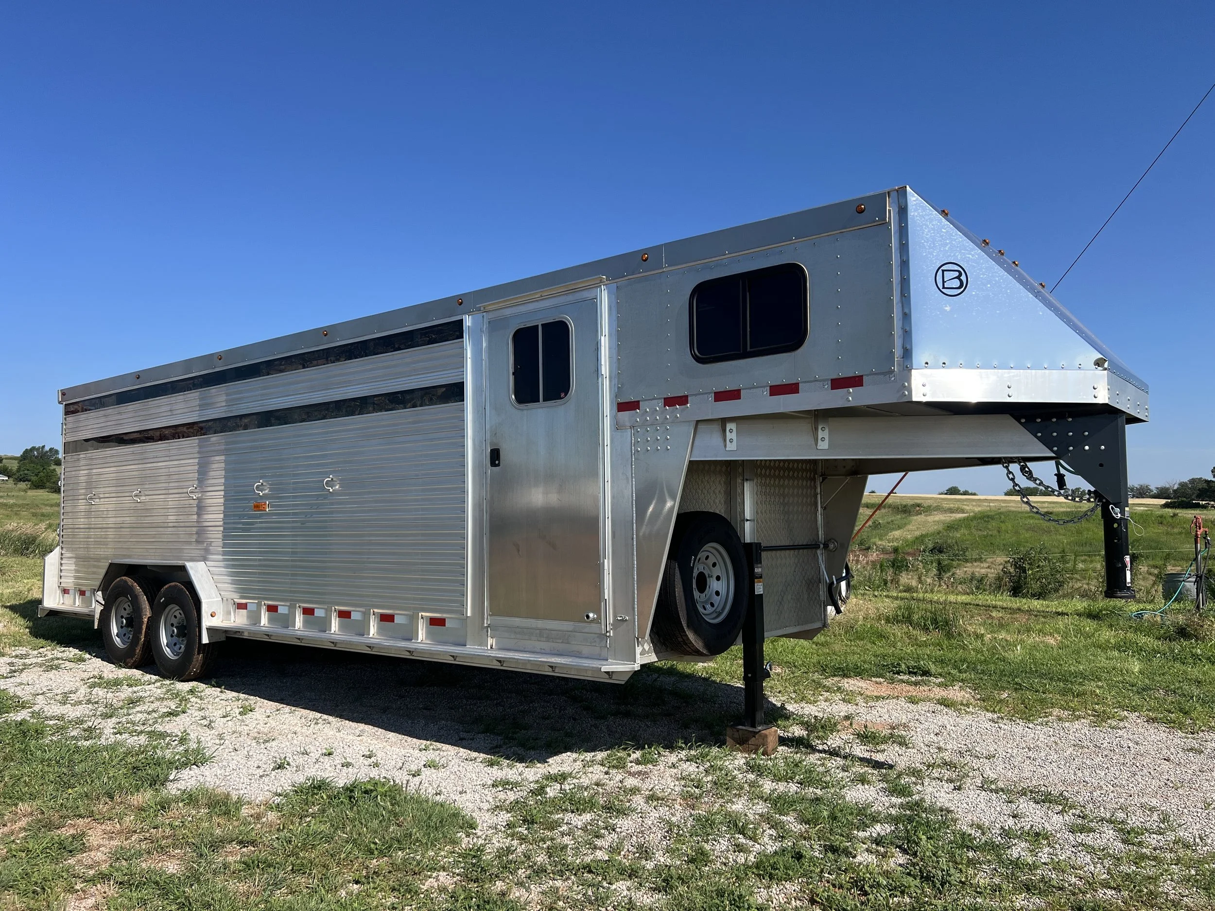 Custom cow trailer with gooseneck hitch parked and ready for livestock hauling