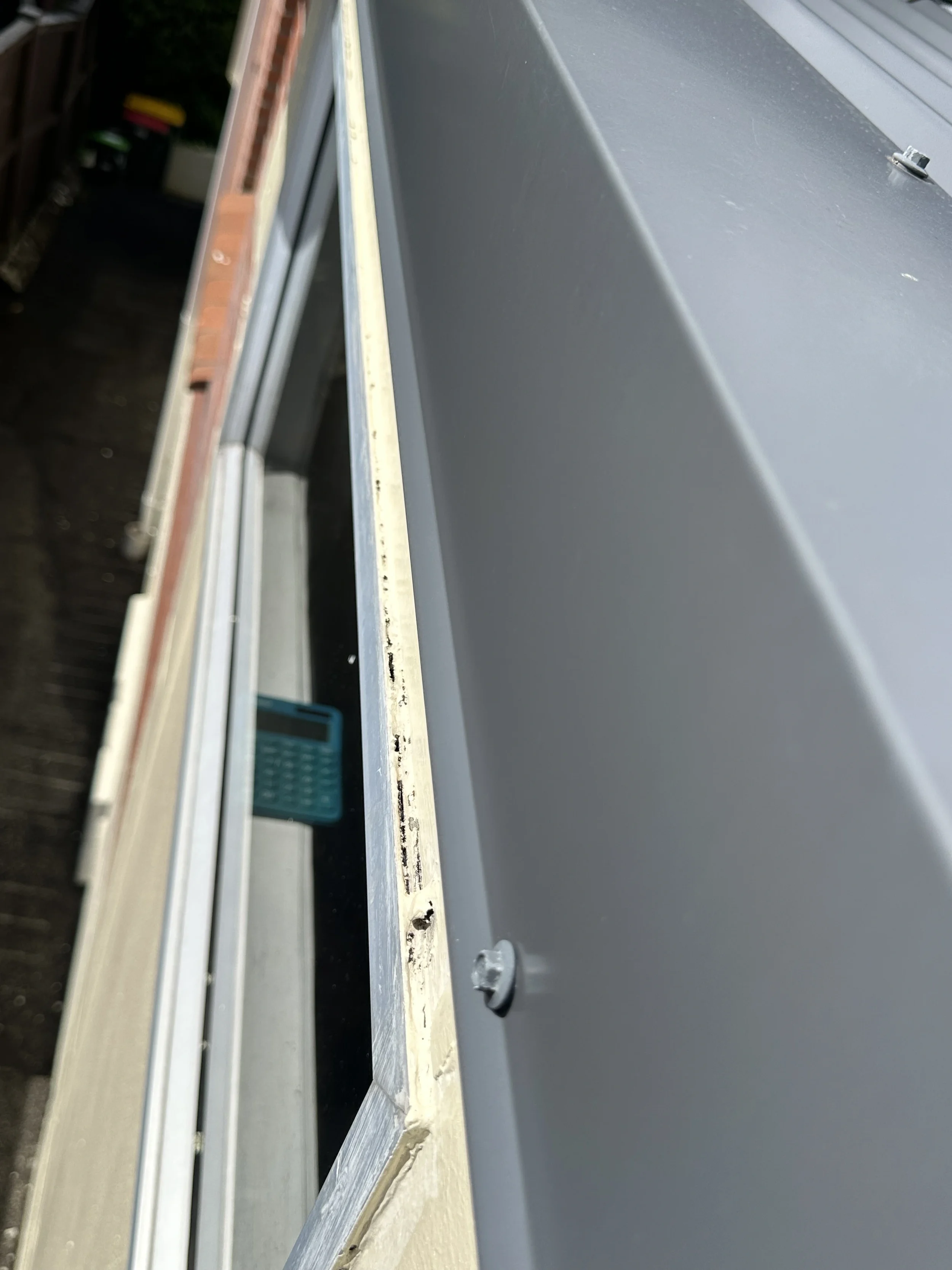 Close-up of cracked silicone and open window junction before flashing repair in Botany