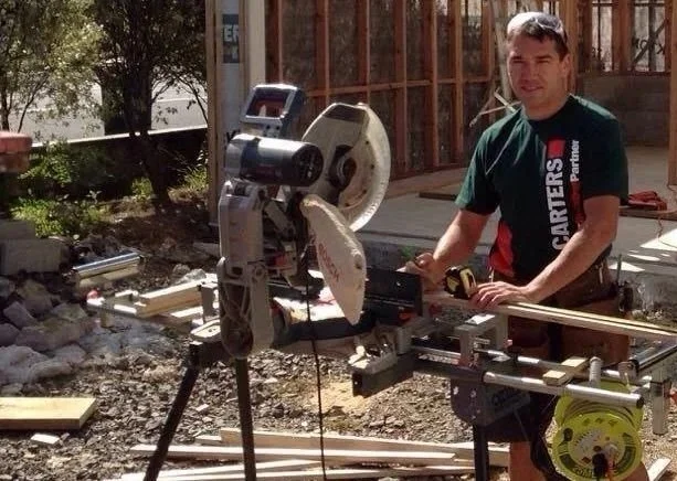 Qualified carpenter cutting timber on a mitre saw at a framing and renovation site in East Auckland — Handyman Botany