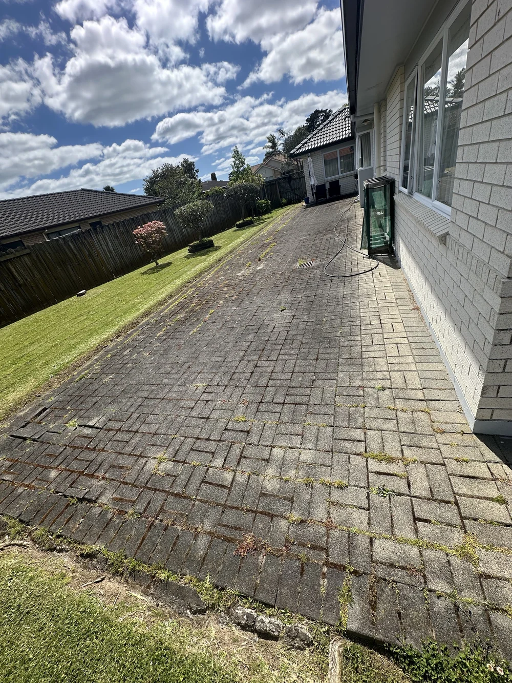 Paving heavily covered with weeds and organic build-up before water
blasting in Golflands