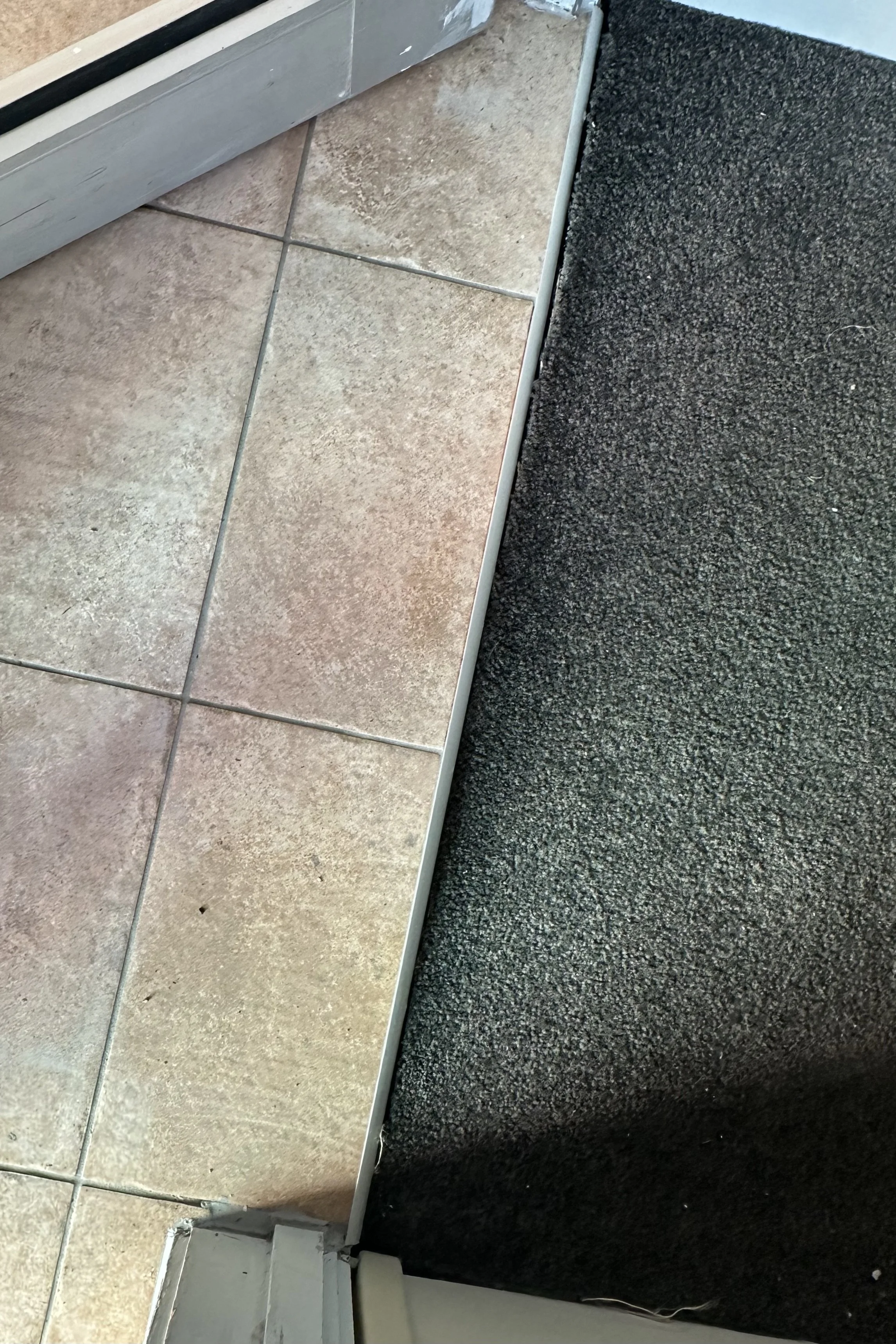 Professionally repaired commercial entrance tiles beside a lift with a seamless finish and restored appearance in Auckland.