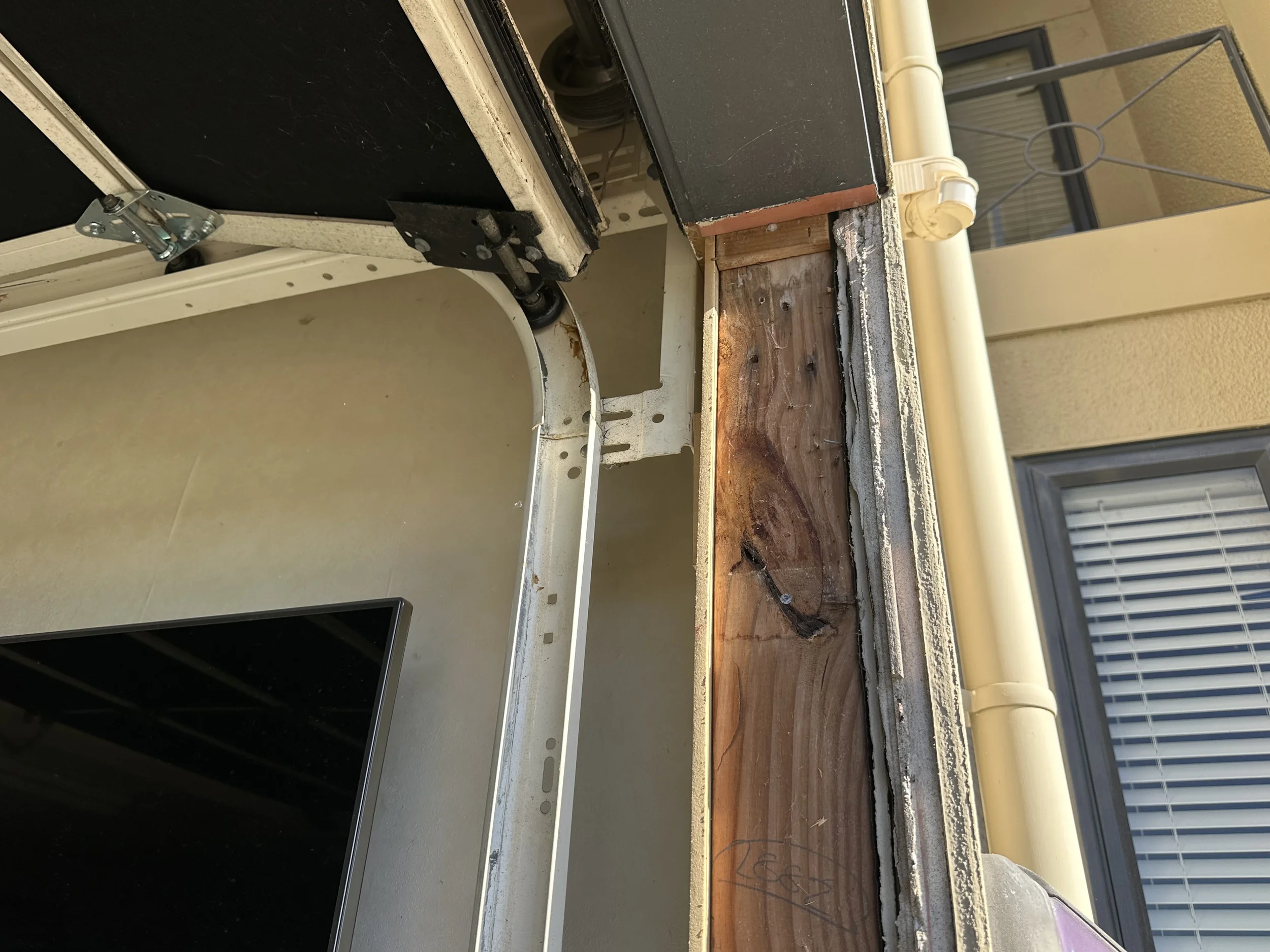 Exposed timber framing behind the removed garage door jamb with no flashing tape protection