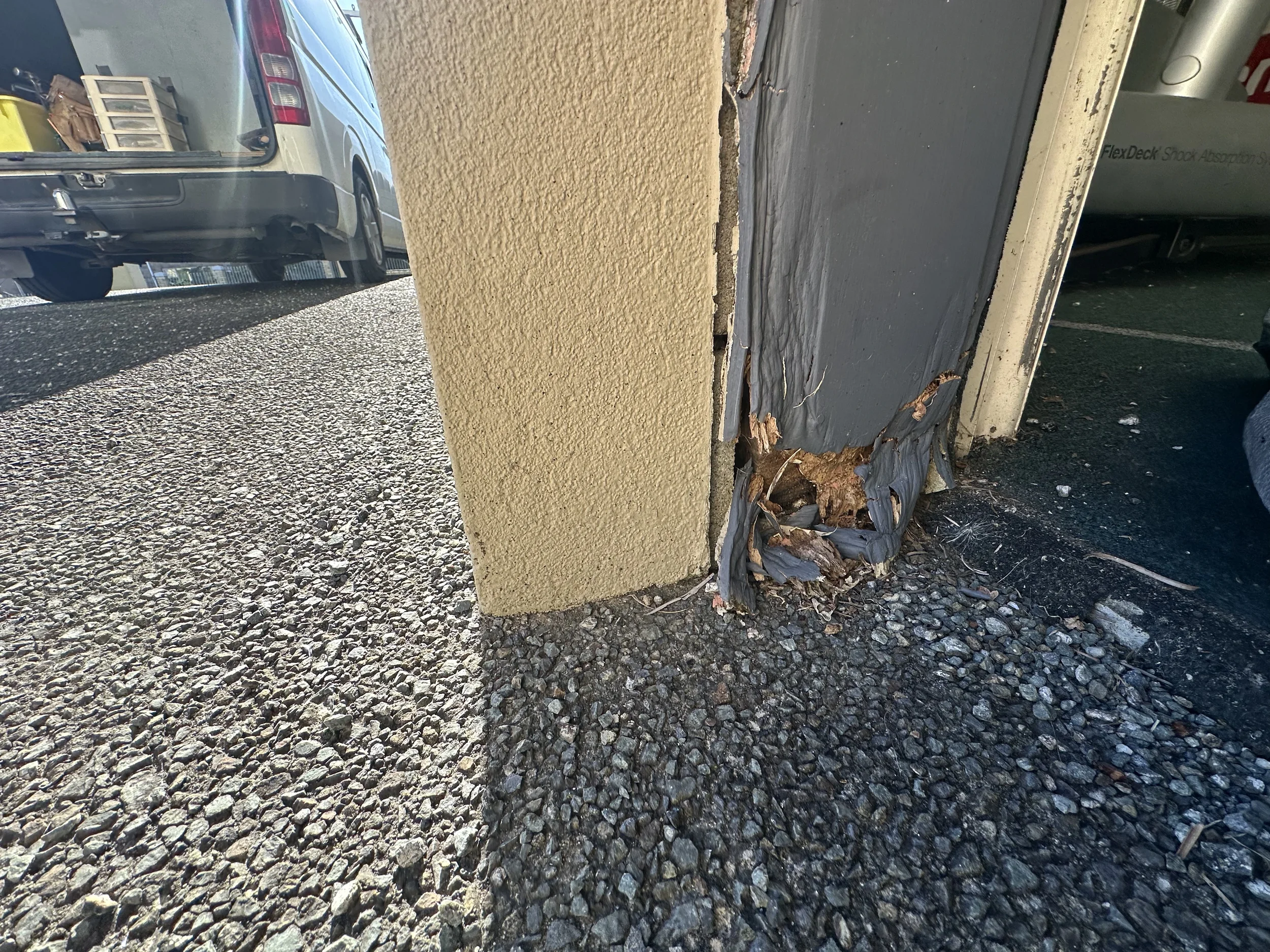 Close-up of severe timber rot at the bottom of a garage door jamb in Somerville