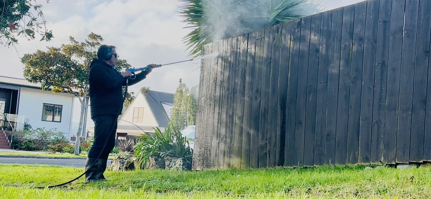 Handyman Botany technician water blasting a timber fence in Howick, clearing moss and built-up grime