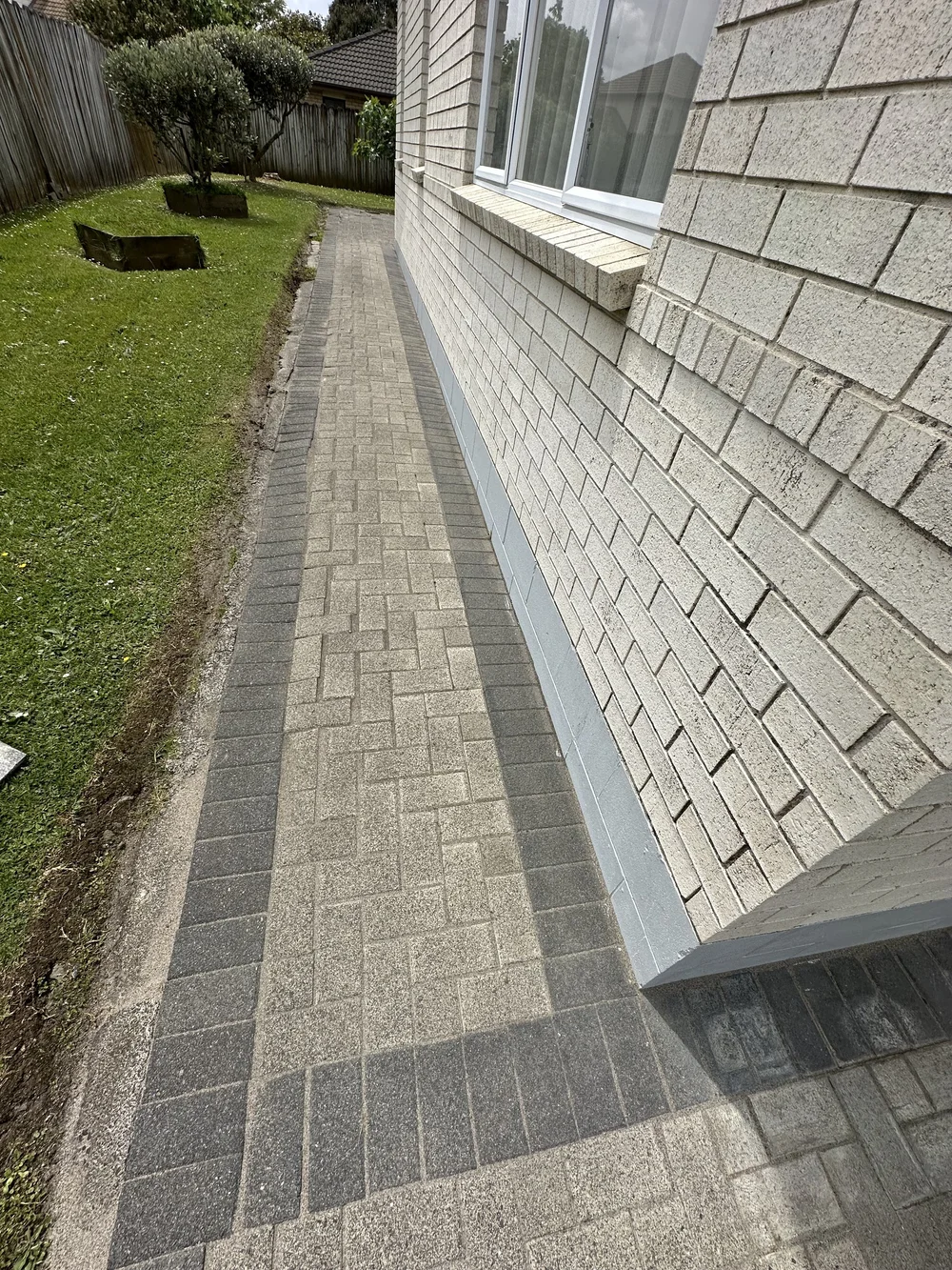 Finished narrow paving path beside a Golflands home after cleaning weed treatment and joint restoration