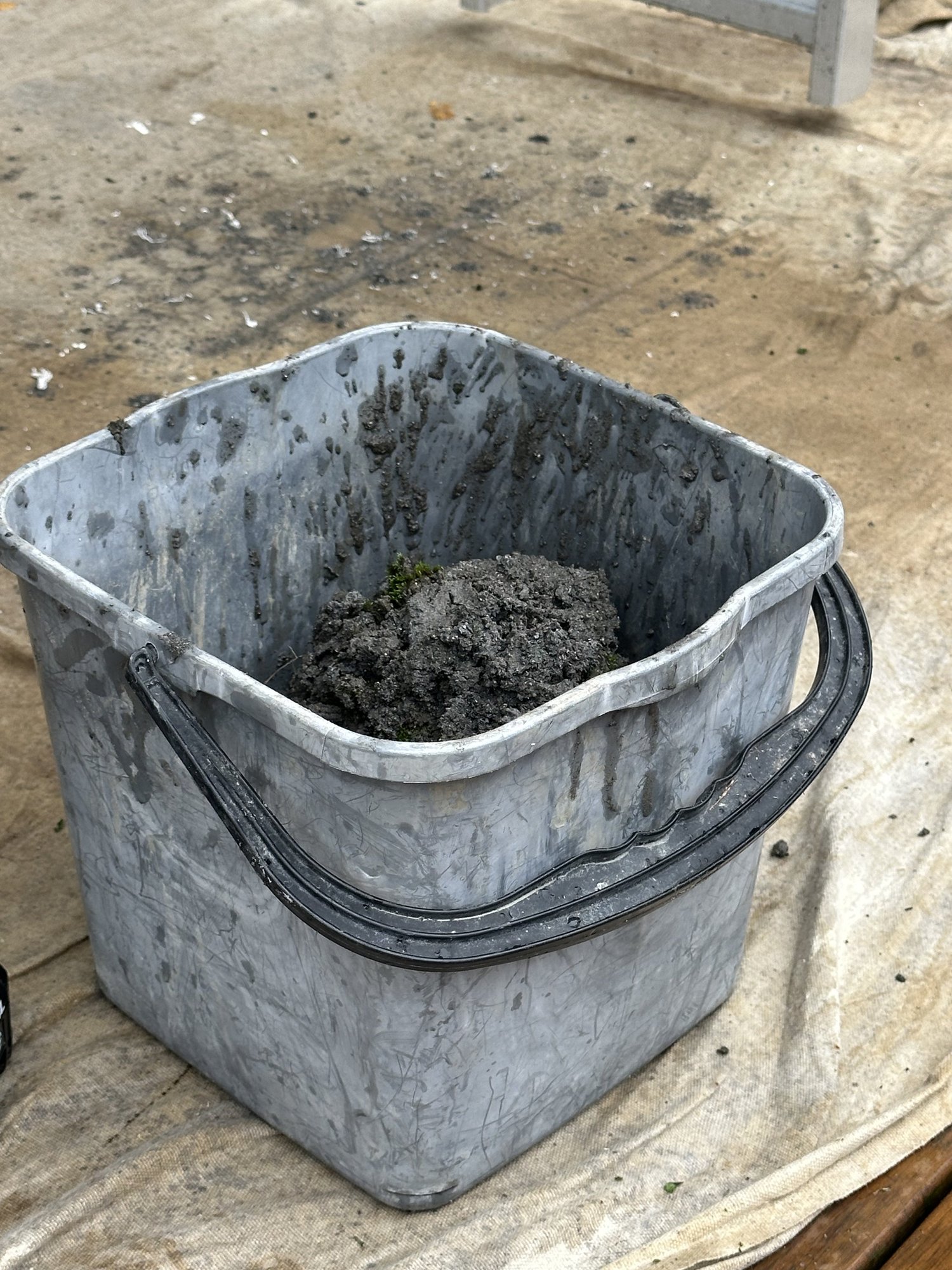 Bucket of heavy sand and organic debris removed from a blocked gutter in Pakuranga