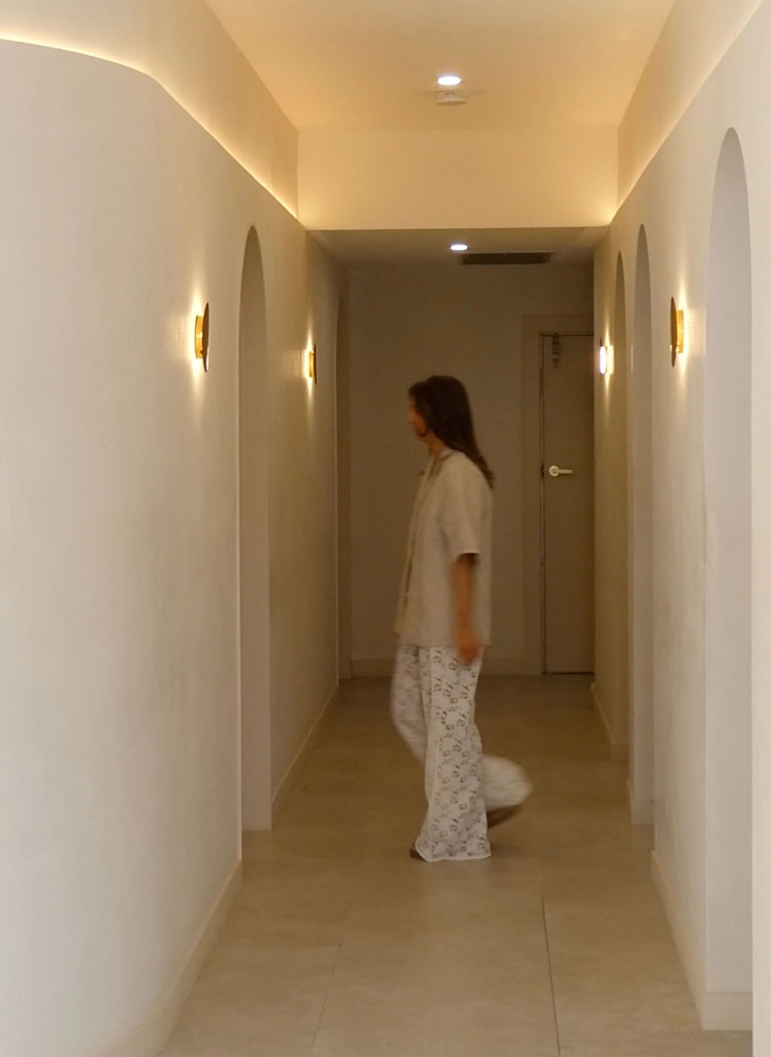 Founder Caitlin Hingst caught walking through the AMIRI Studio in Newcastle from BIAB nail room to brow and lash service room.