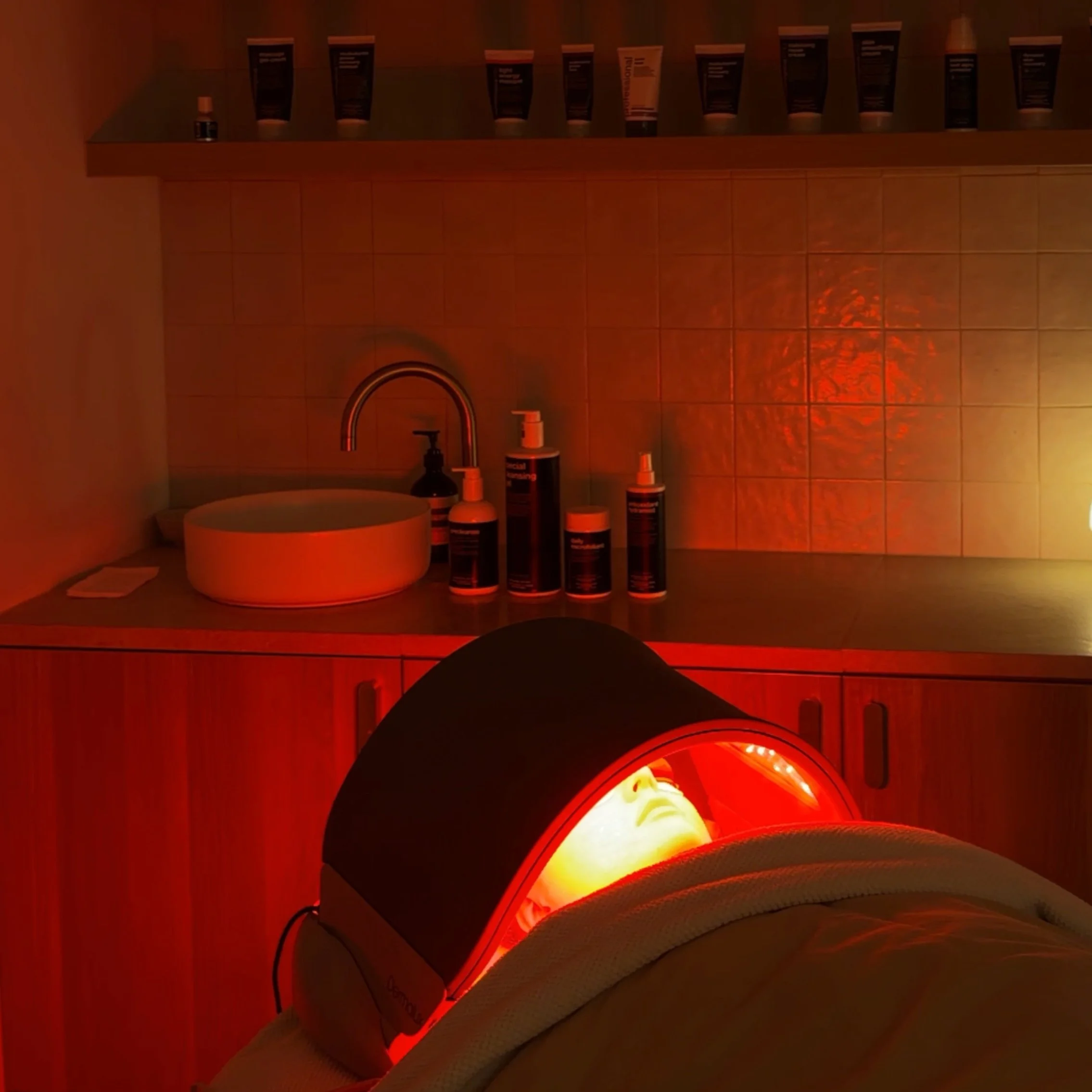 A Dermalux LED covering a womans face in a facial room within Amiri Studio