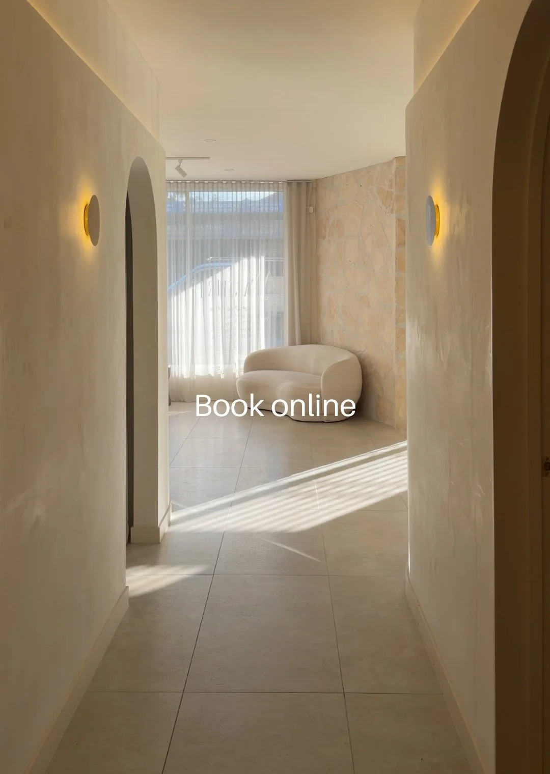 A light filled hallway in the Amiri Studio Newcastle space with washed walls and a boucle lounge.